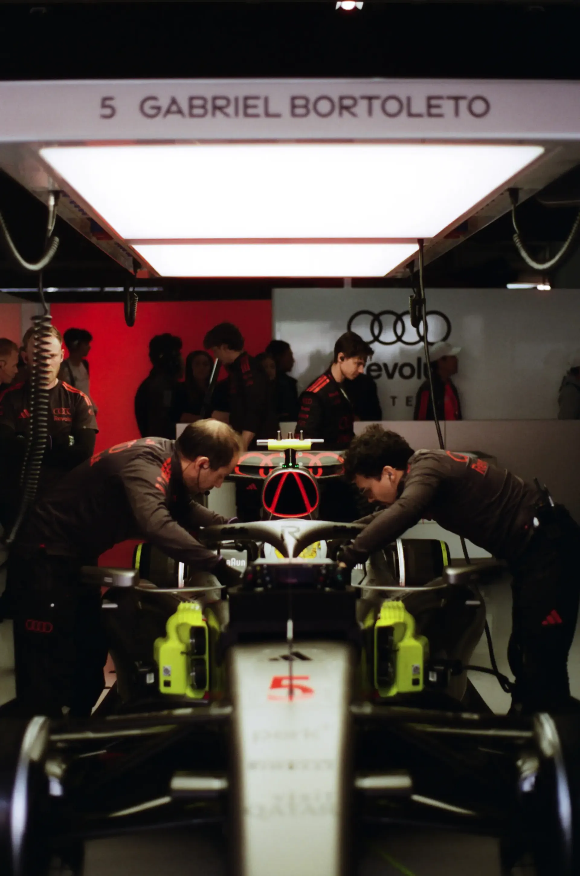 Audi Revolut F1® Team mechanics work on Gabriel Bortoleto's Audi R26 inside the garage.