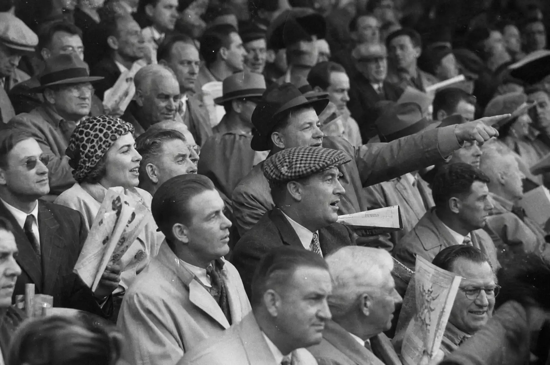 Historic black-and-white photograph of spectators watching racing from the Silverstone grandstands.