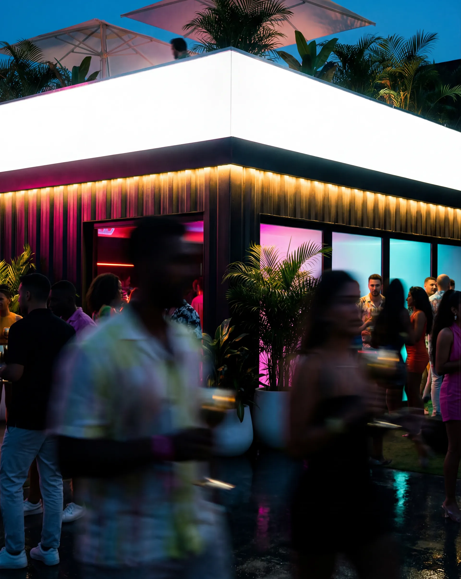 Crowd gathering outside modern Miami venue with neon lighting at night