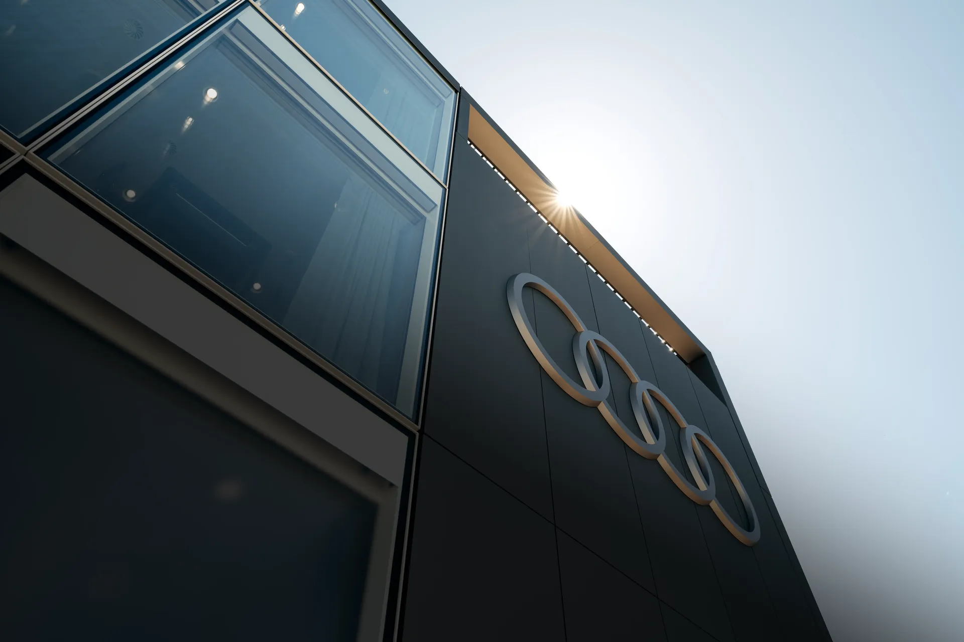 Side-front view of the new Audi Revolut F1® Team hospitality hub with prominent Audi rings mounted on the facade.