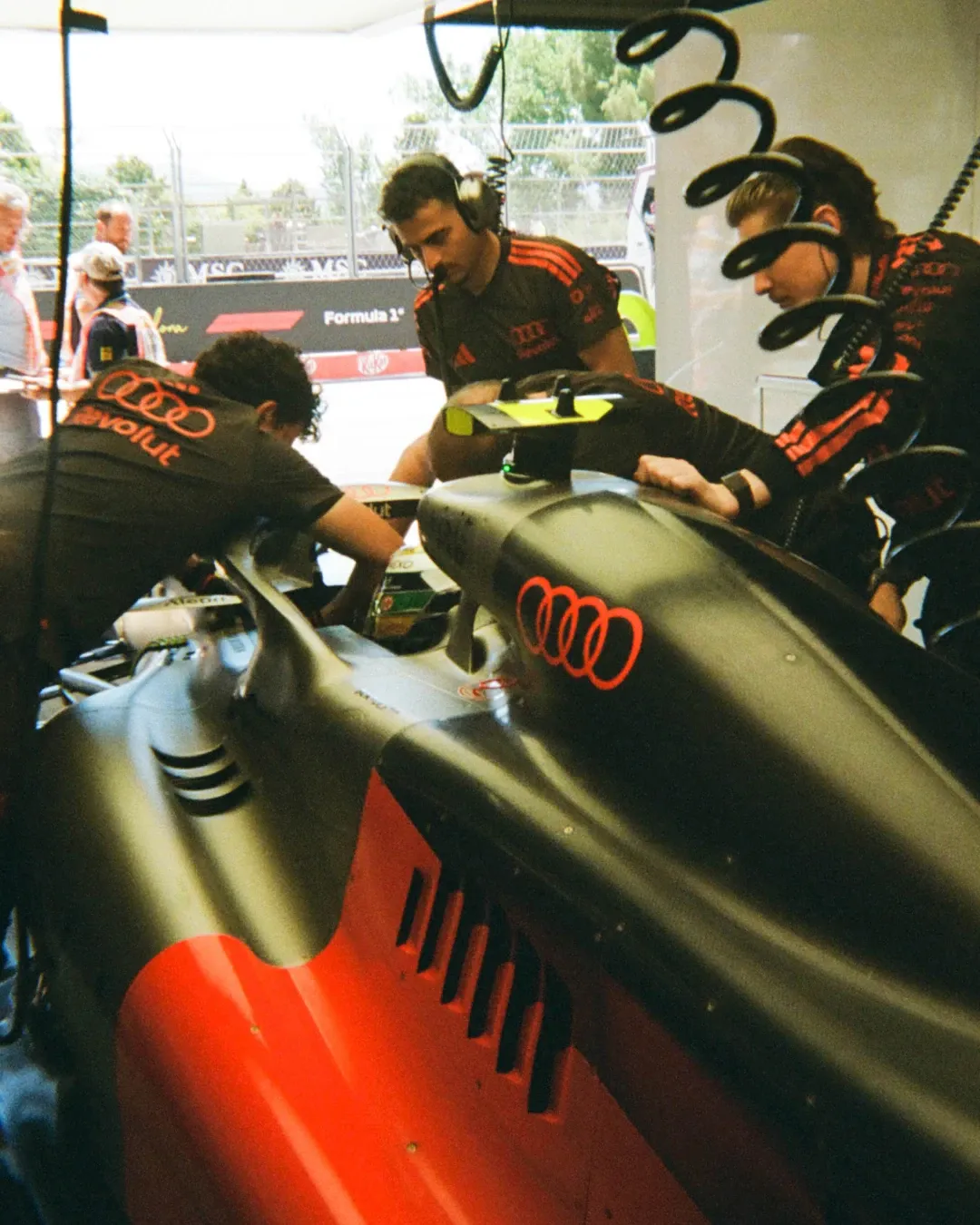 Audi Revolut F1® Team members work around the race car inside the garage.