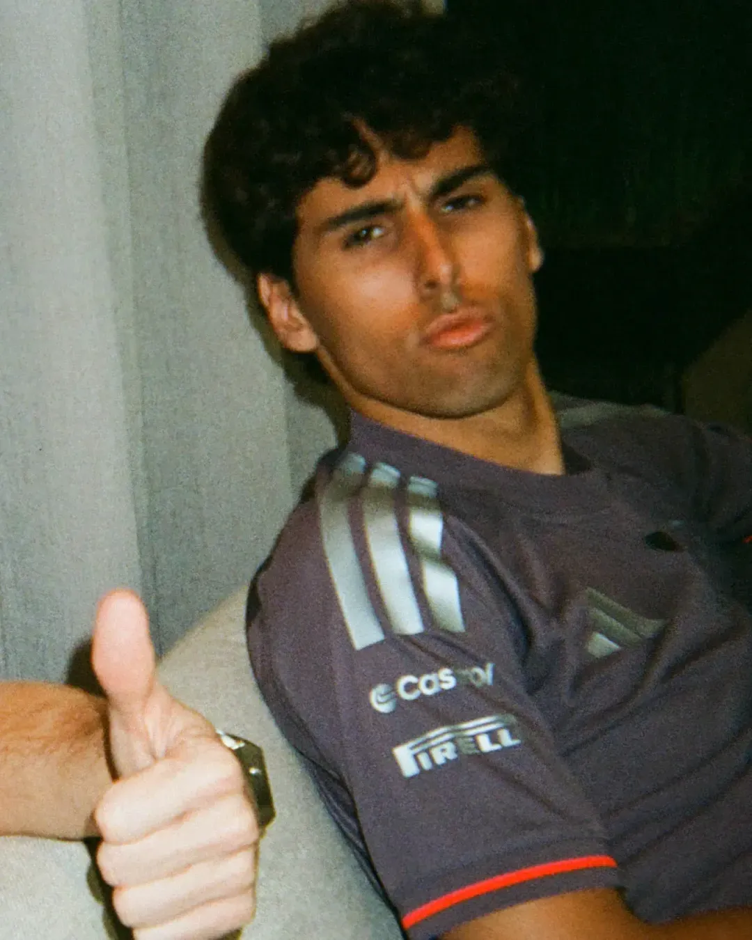 Gabriel Bortoleto lounges on a sofa while someone gives a thumbs-up to the camera.