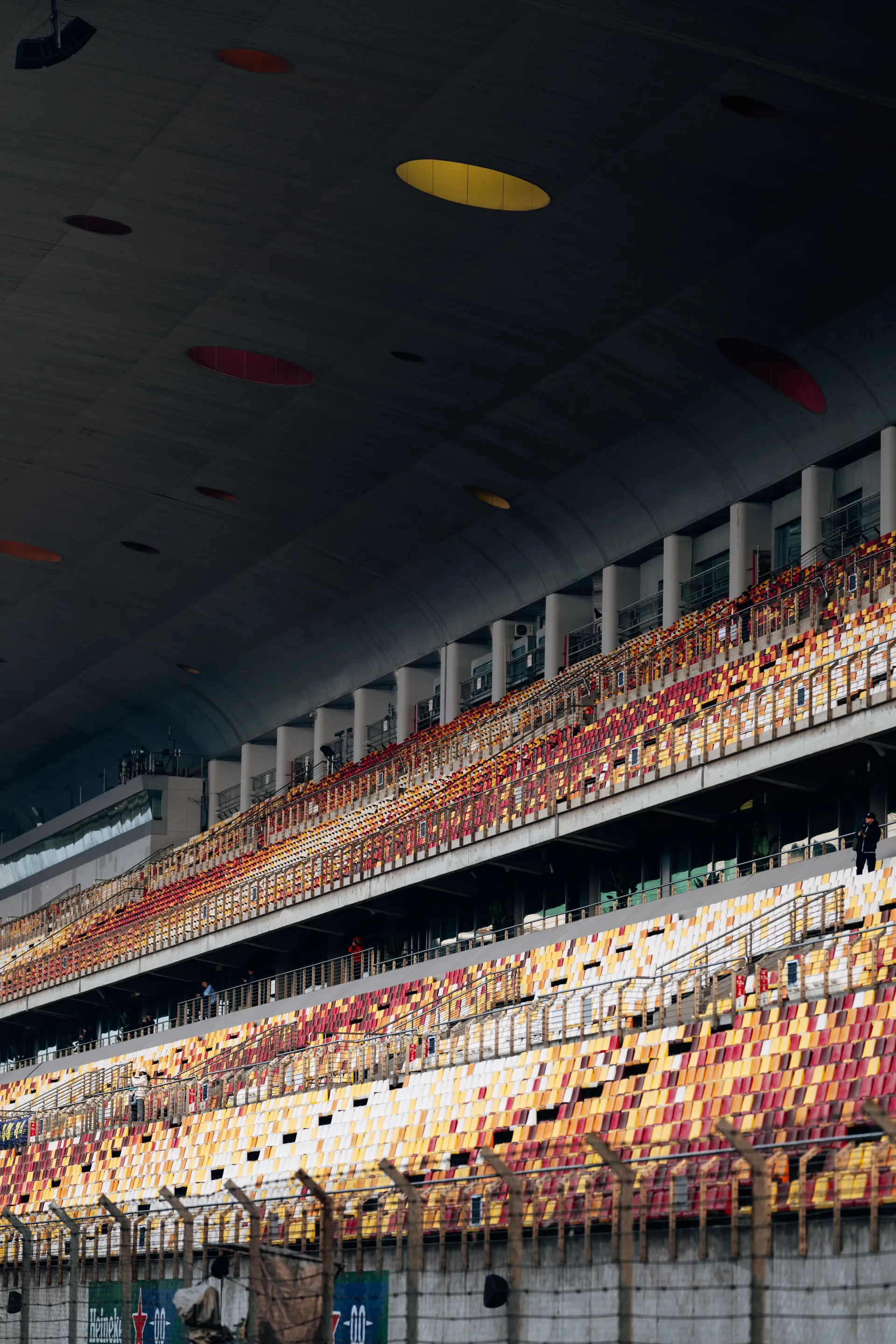 Colorful empty seating rows inside a covered F1 grandstand