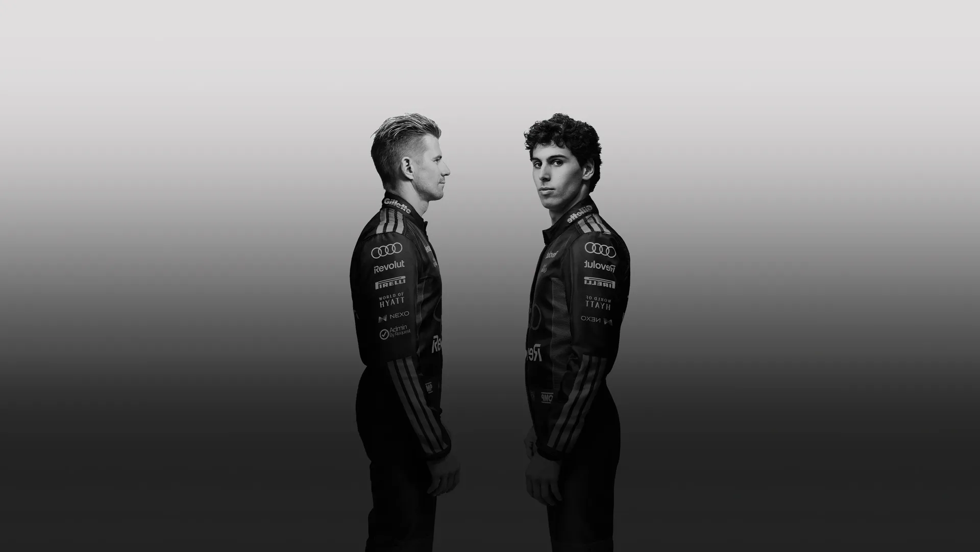 Black and white sideshot of Nico Hulkenberg and Gabvriel Bortoleto drivers at the Audi Revolut F1® Team faceing each other in the studio