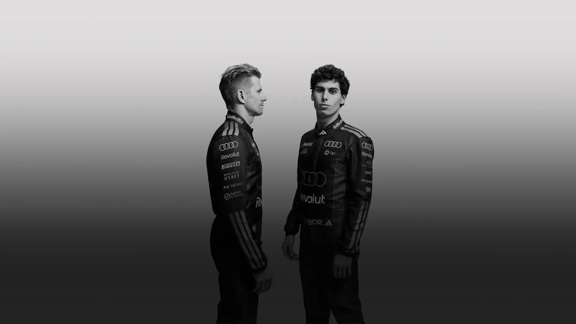 Black and white sideshot of Nico Hulkenberg and Gabvriel Bortoleto drivers at the Audi Revolut F1® Team faceing each other in the studio