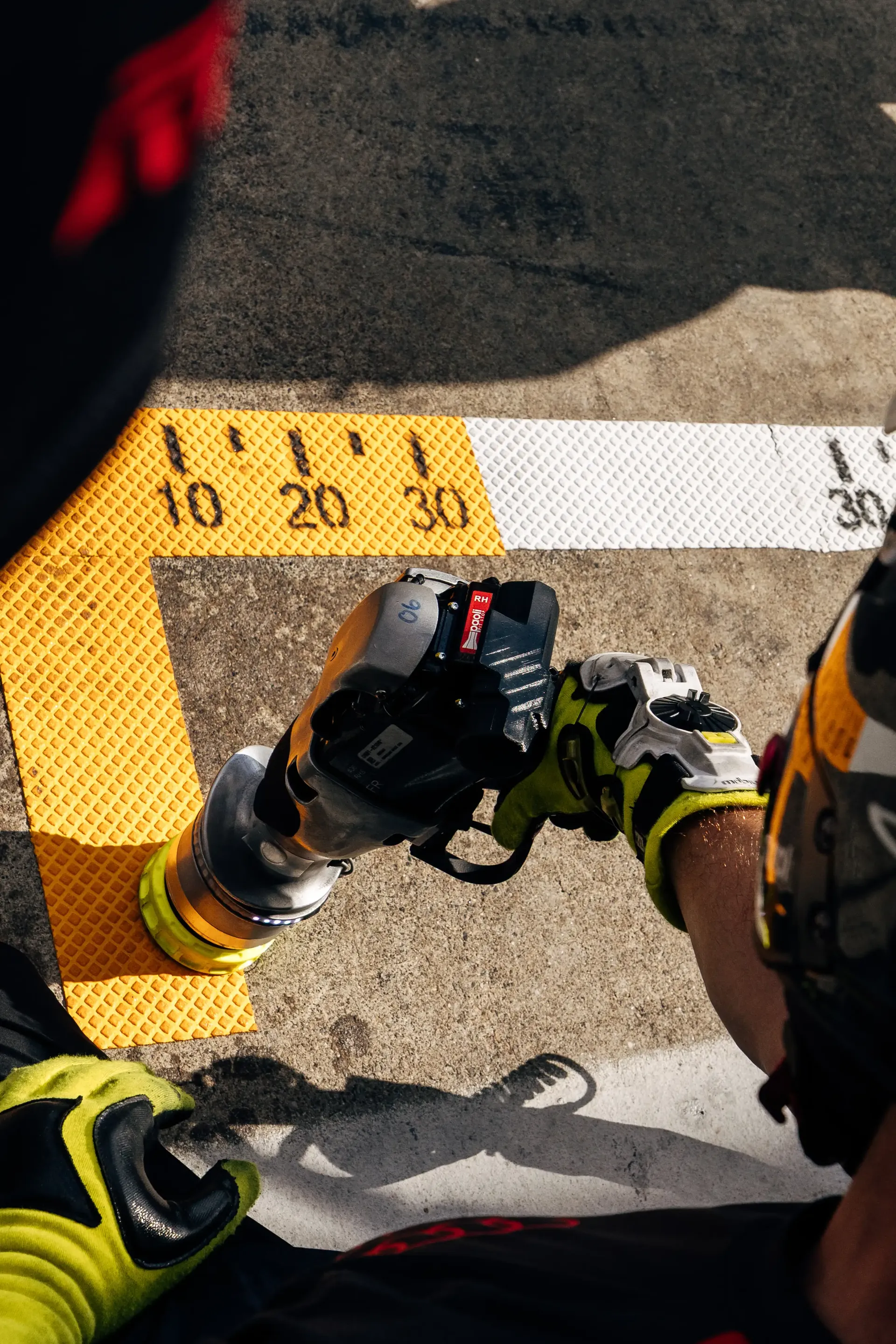 Overhead view of a mechanic working on pit lane equipment.