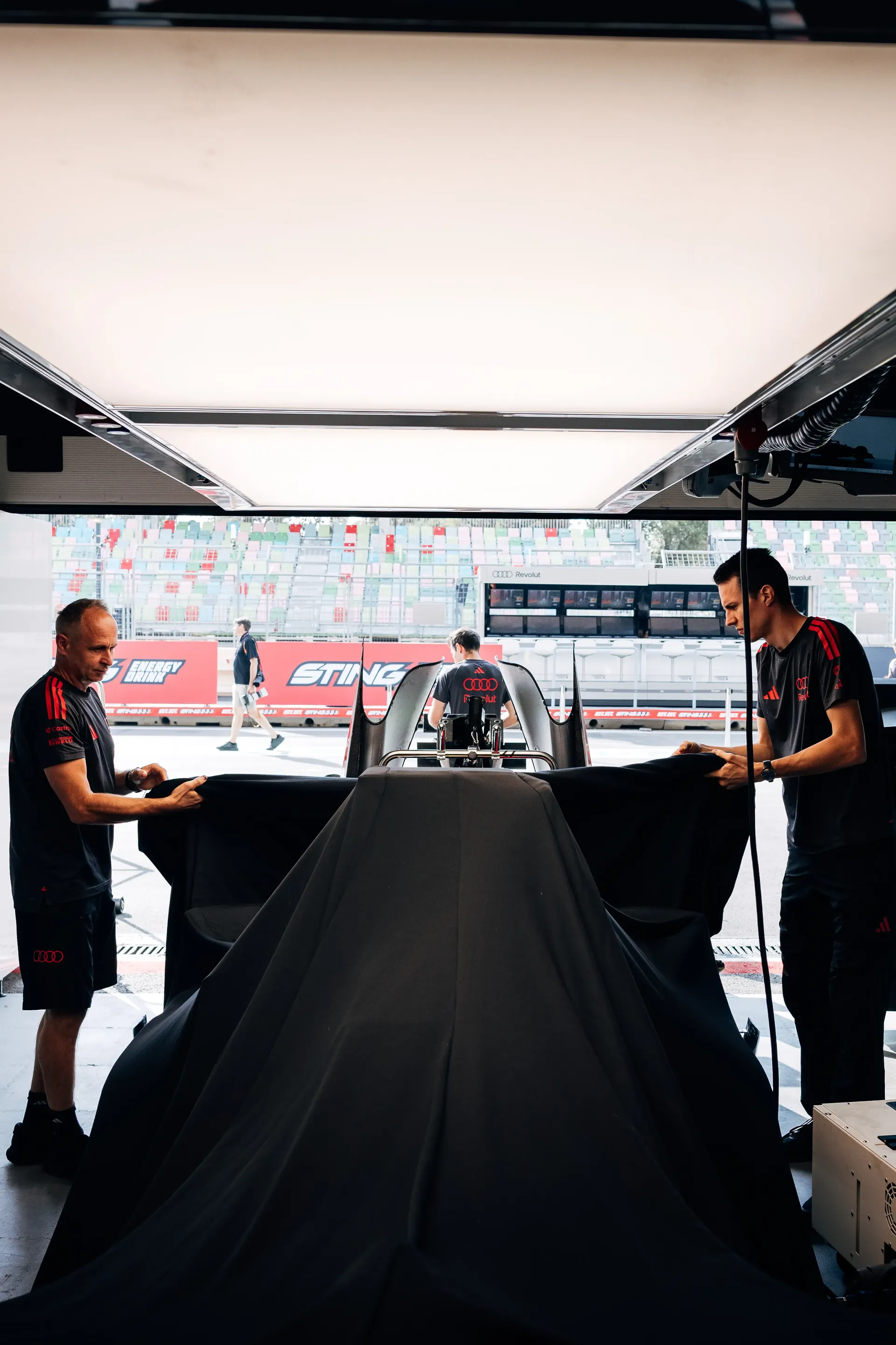 Audi Revolut F1® Team mechanics reavealing the Audi R26 and working in the garage
