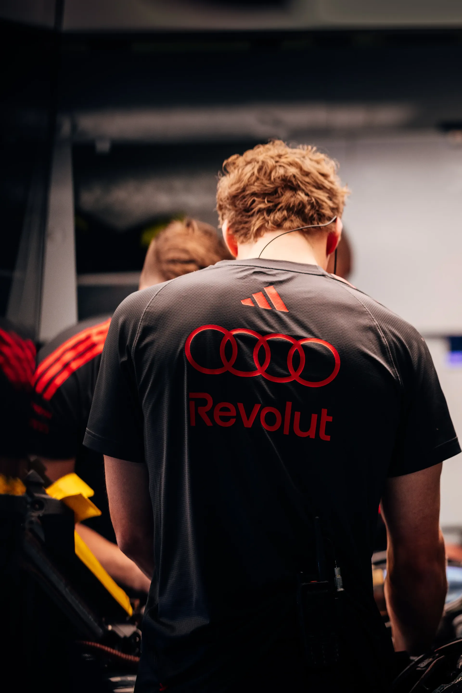 Back shot of Audi Revolut F1® Team mechanics working in the garage