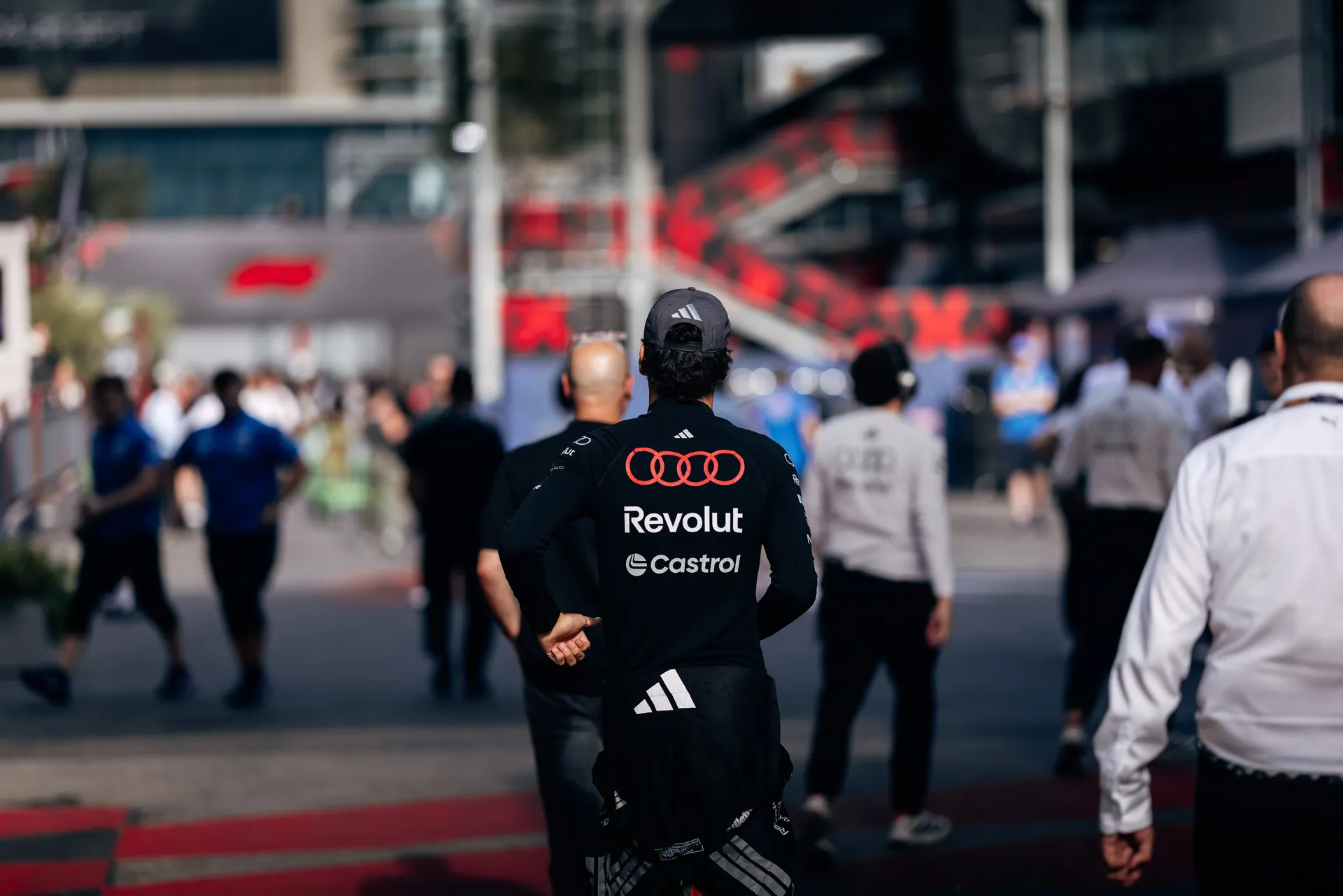 Audi Revolut F1® Team driver Gabriel Bortoleto in team kit walking aroudn the paddock