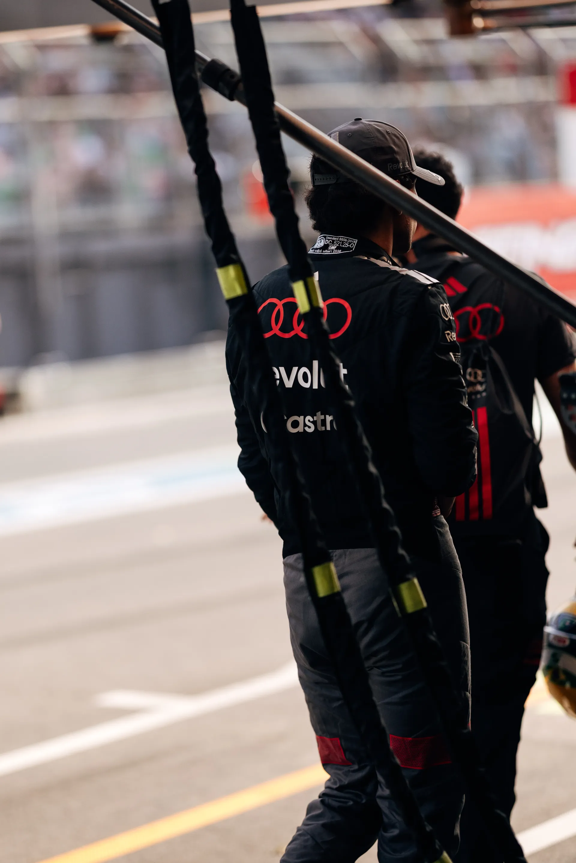 Audi Revolut F1® Team mechanics walking through the pit lane