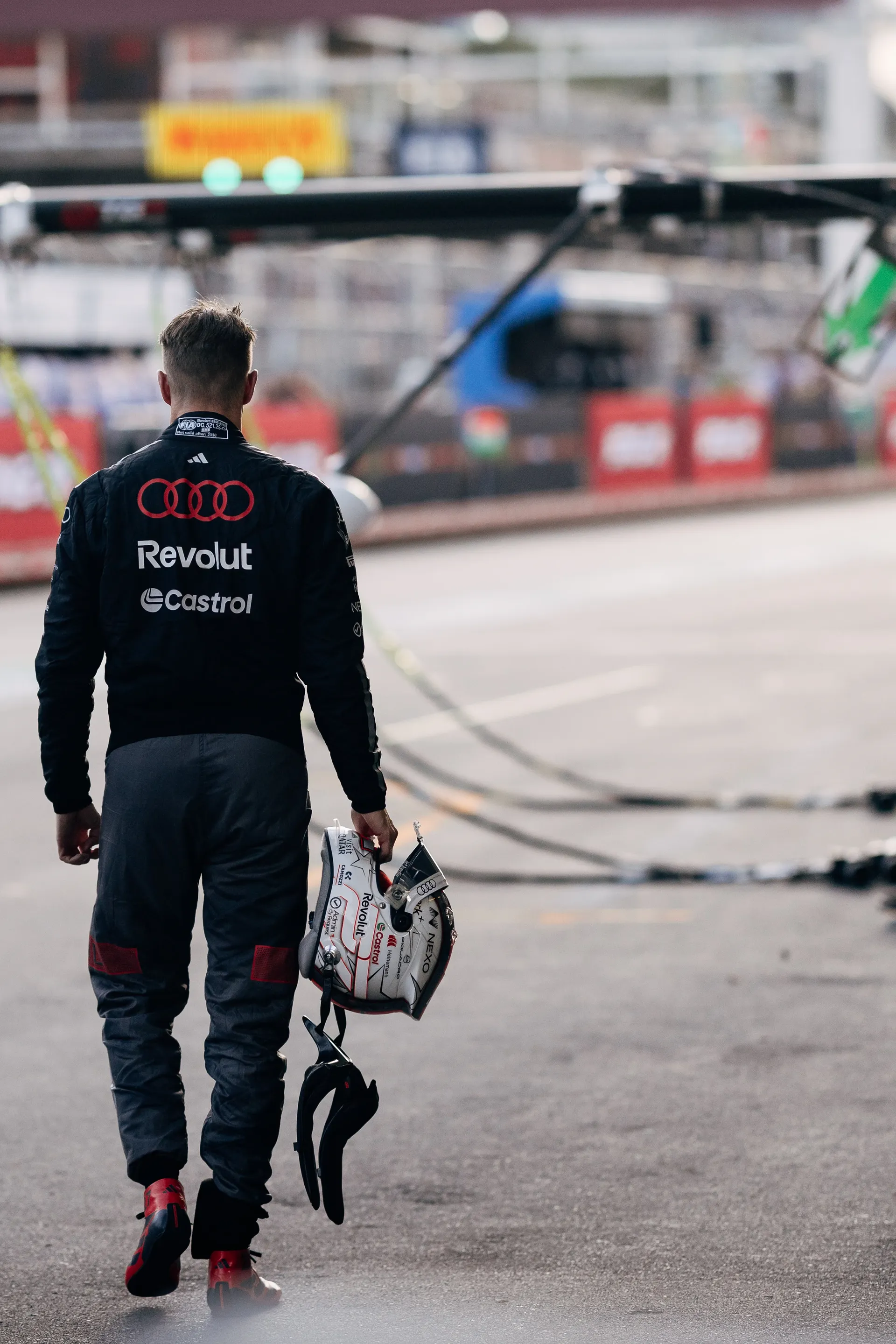 Audi Revolut F1® Team driver Nico Hulkenberg walking through the pit lane with his helmet