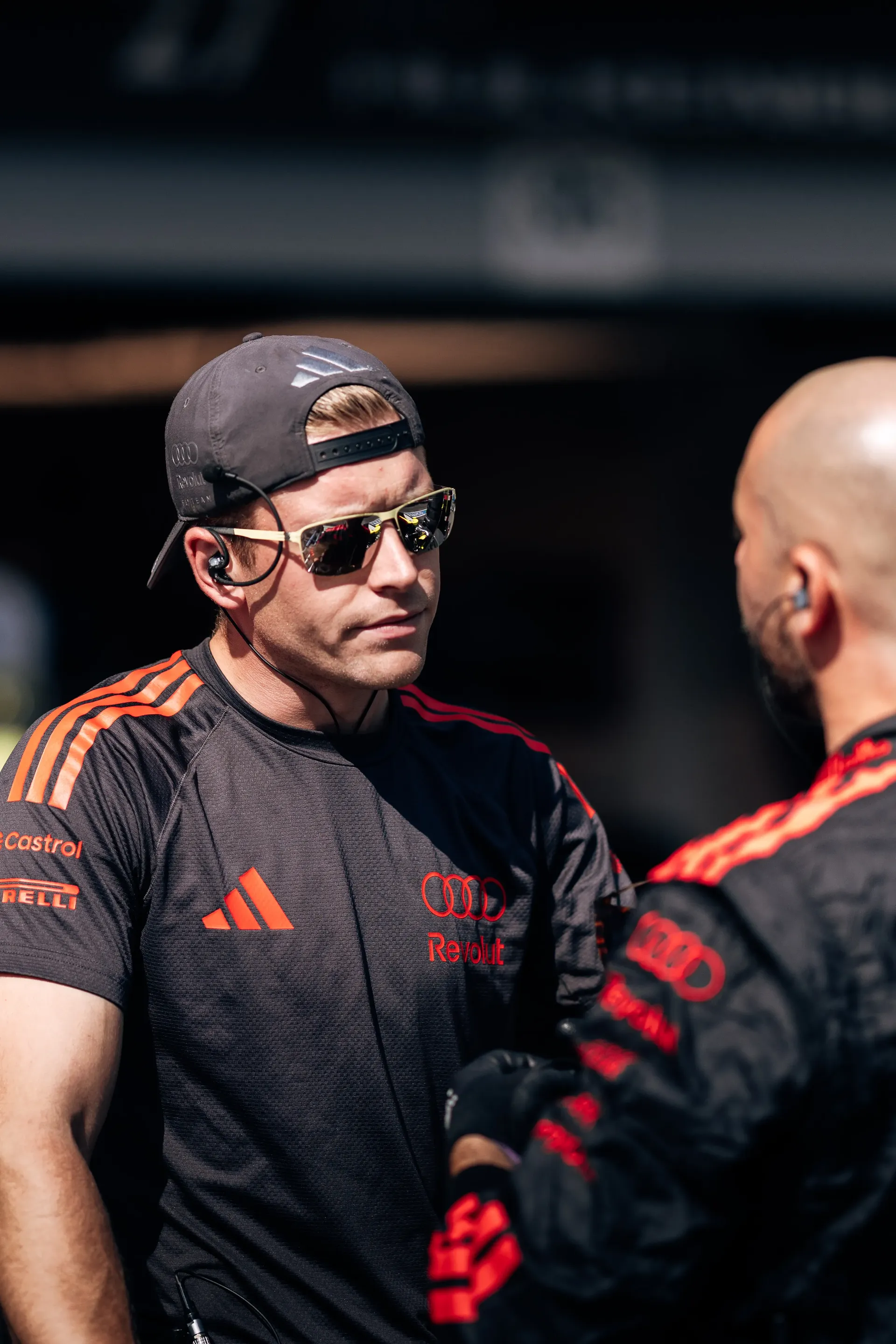 Audi Revolut F1® Team mechanic speaking with a team member in the paddock.