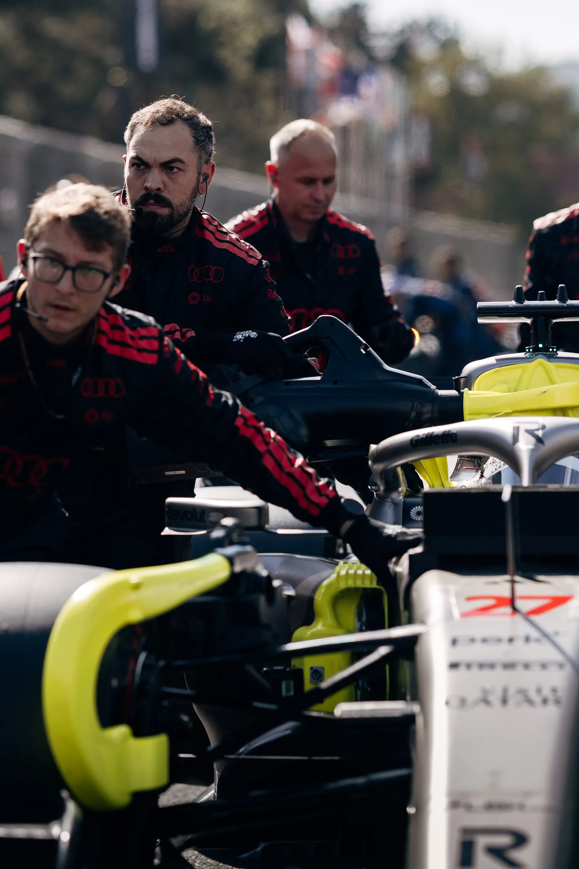 Audi Revolut F1® Team mechanics preparing the car in the paddock.