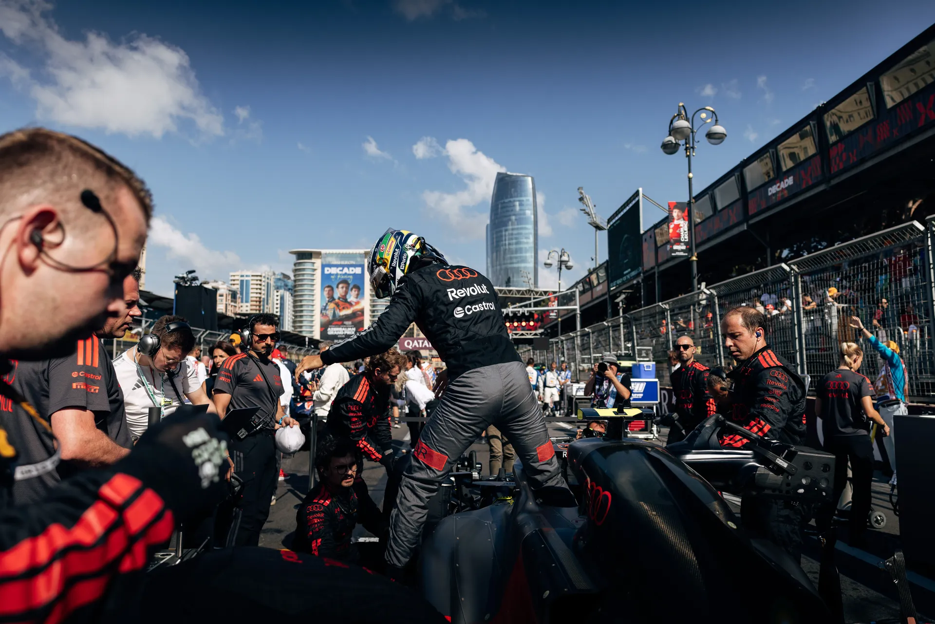 Audi Revolut F1® Team mechanics working around the car in the pit lane.