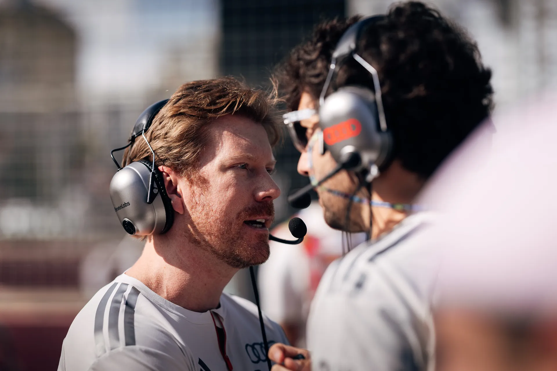 Audi Revolut F1® Team engineer speaking with a team member in the paddock.