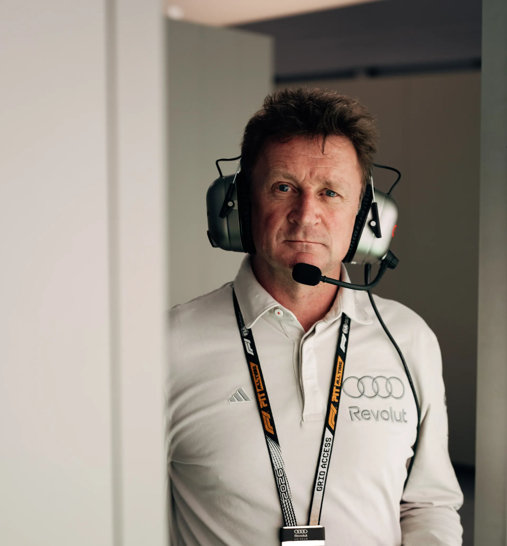 Allan McNish, Racing Director of the Audi Revolut F1® Team, wearing a headset in the garage