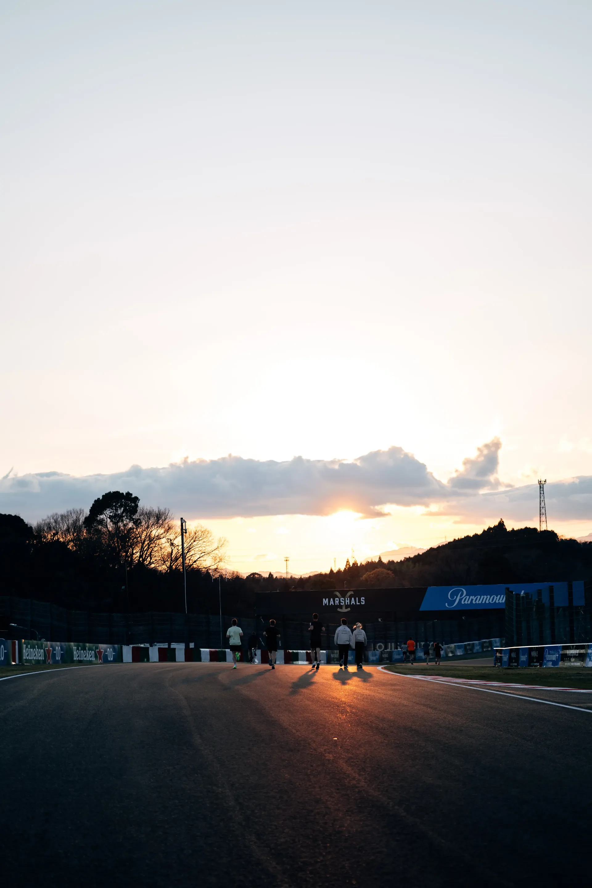 Audi Revolut F1® Team walking on the racetrack towards the sundown