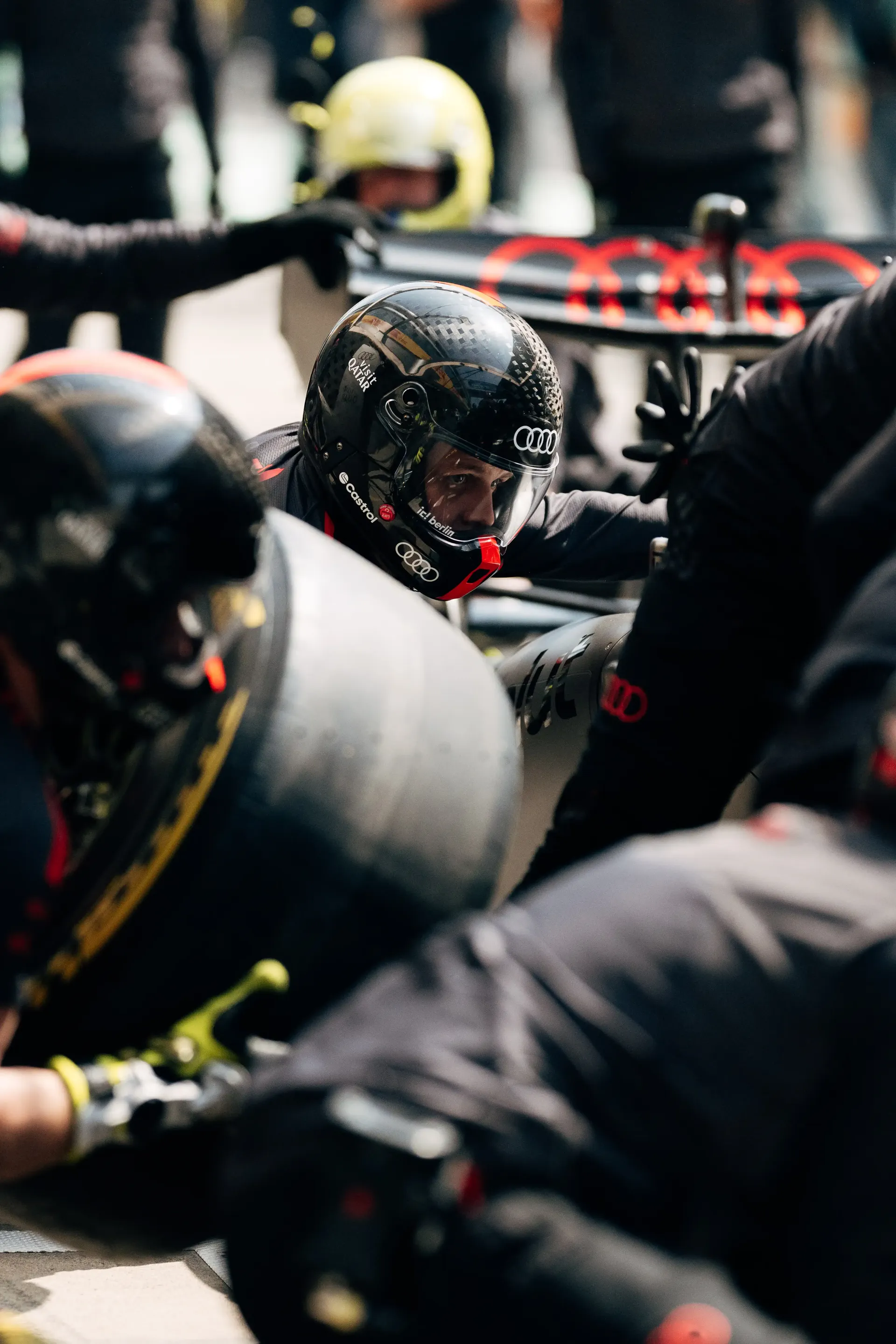 Audi Revolut F1® Team crew in black gear changing tire during a fast pit stop