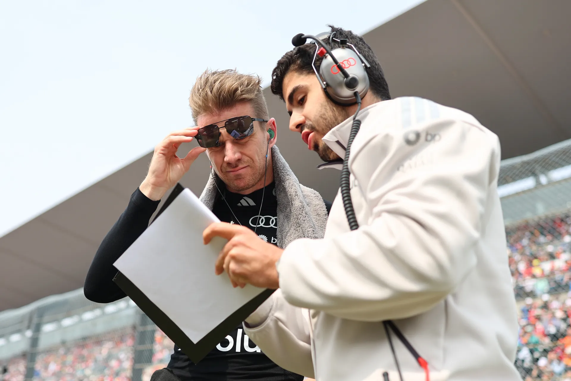 Nico Hulkenberg driver of the Audi Revolut F1® Team and crew engineer discussing strategy on the racetrack