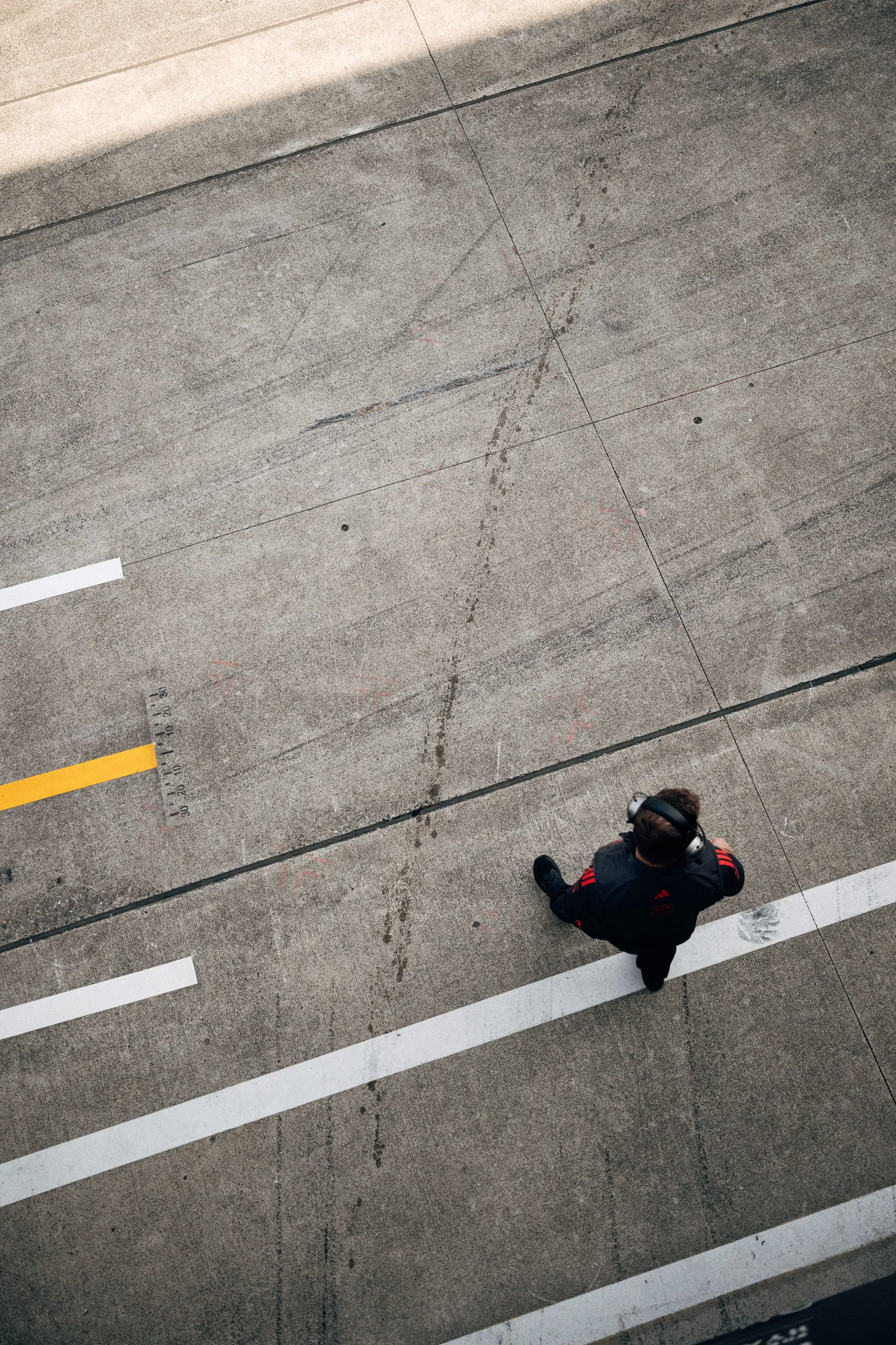 Bird view of Audi Revolut F1® Team mechanic leaving the garage and arriving at the racetrack