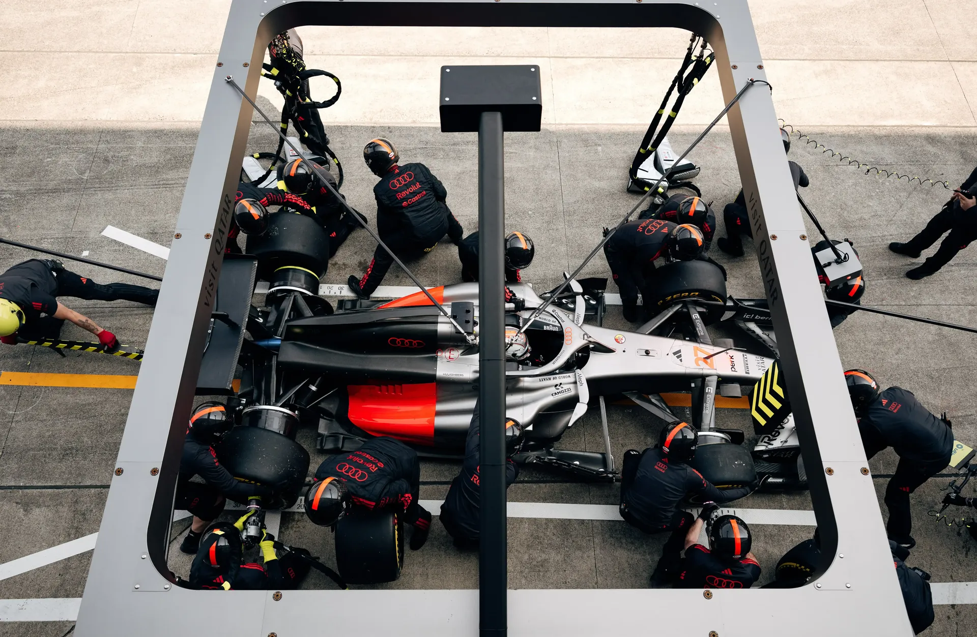 Top view of the Audi Revolut F1® Team car at the pit stop surrounded by team mechanics