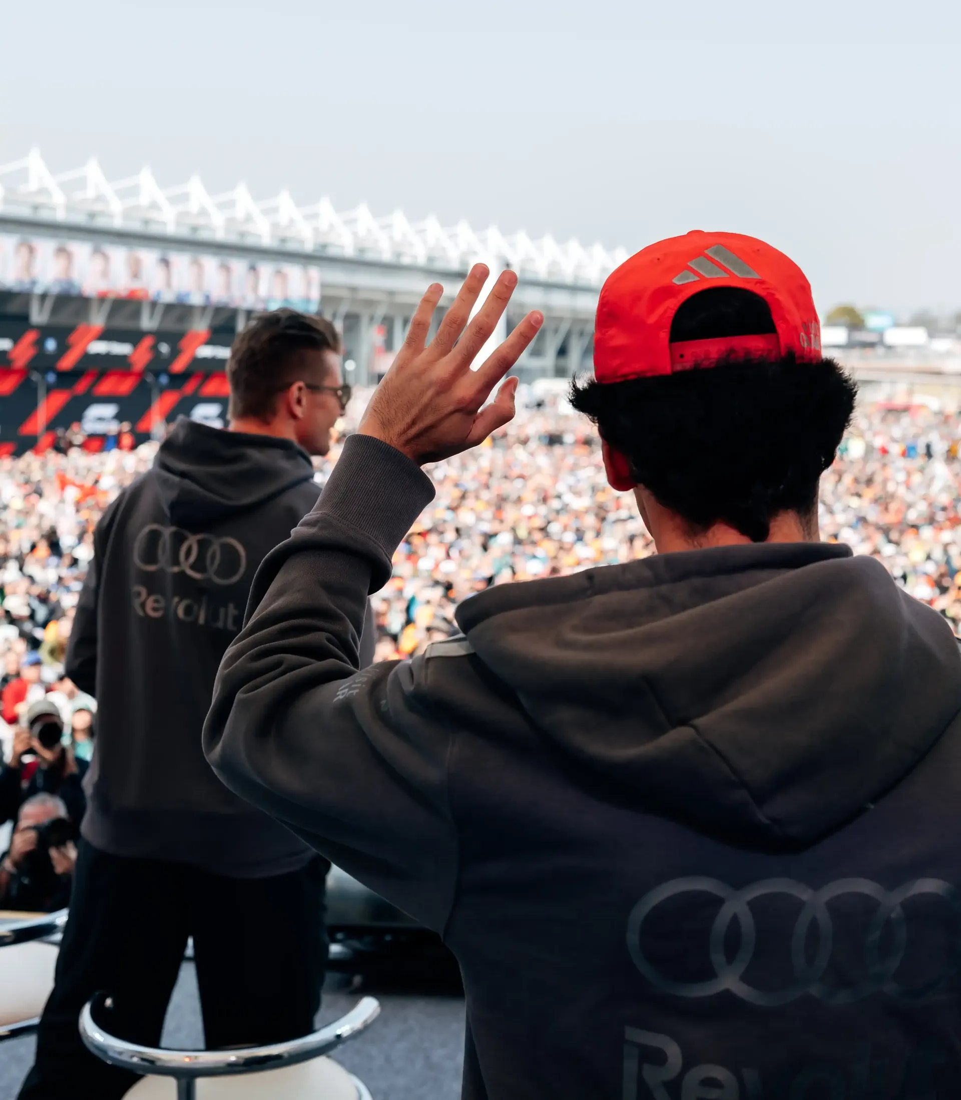 Nico Hulkenberg and Gabriel Bortoleto drivers of the Audi Revolut F1® Team arriving at the racetrack surounded by fans