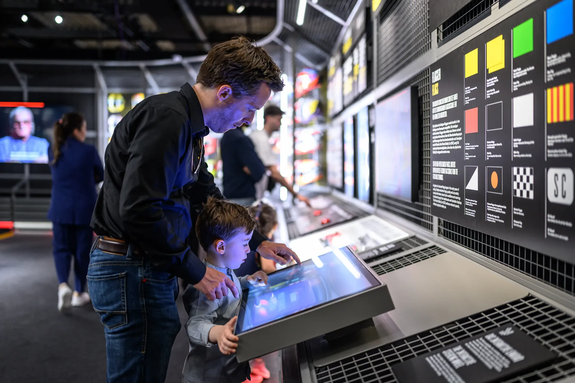 Family interacting with hands-on Formula 1 exhibition displays and digital content
