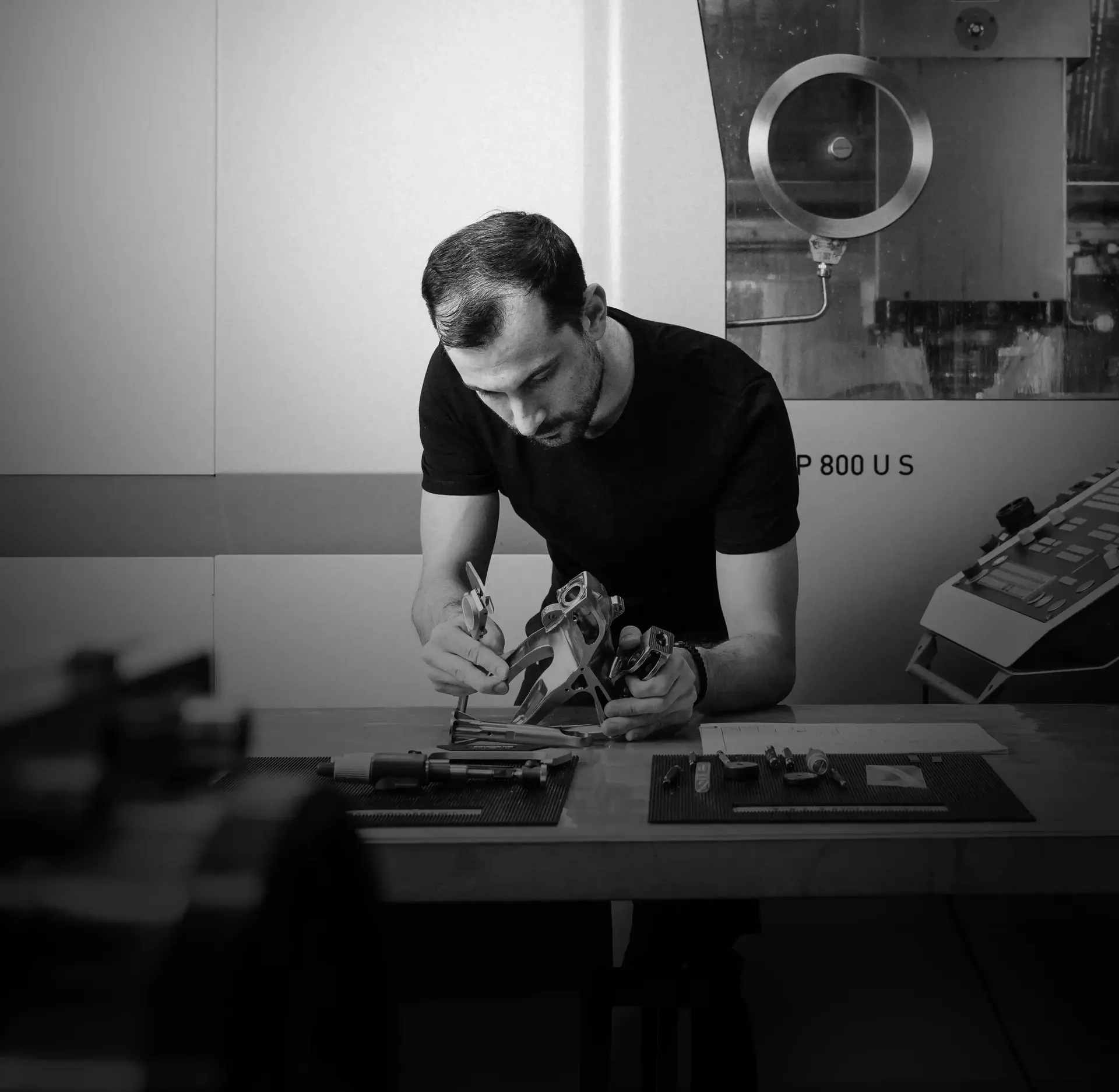 Black and whit portrait of Giovanni at his working desk using a CNC tool