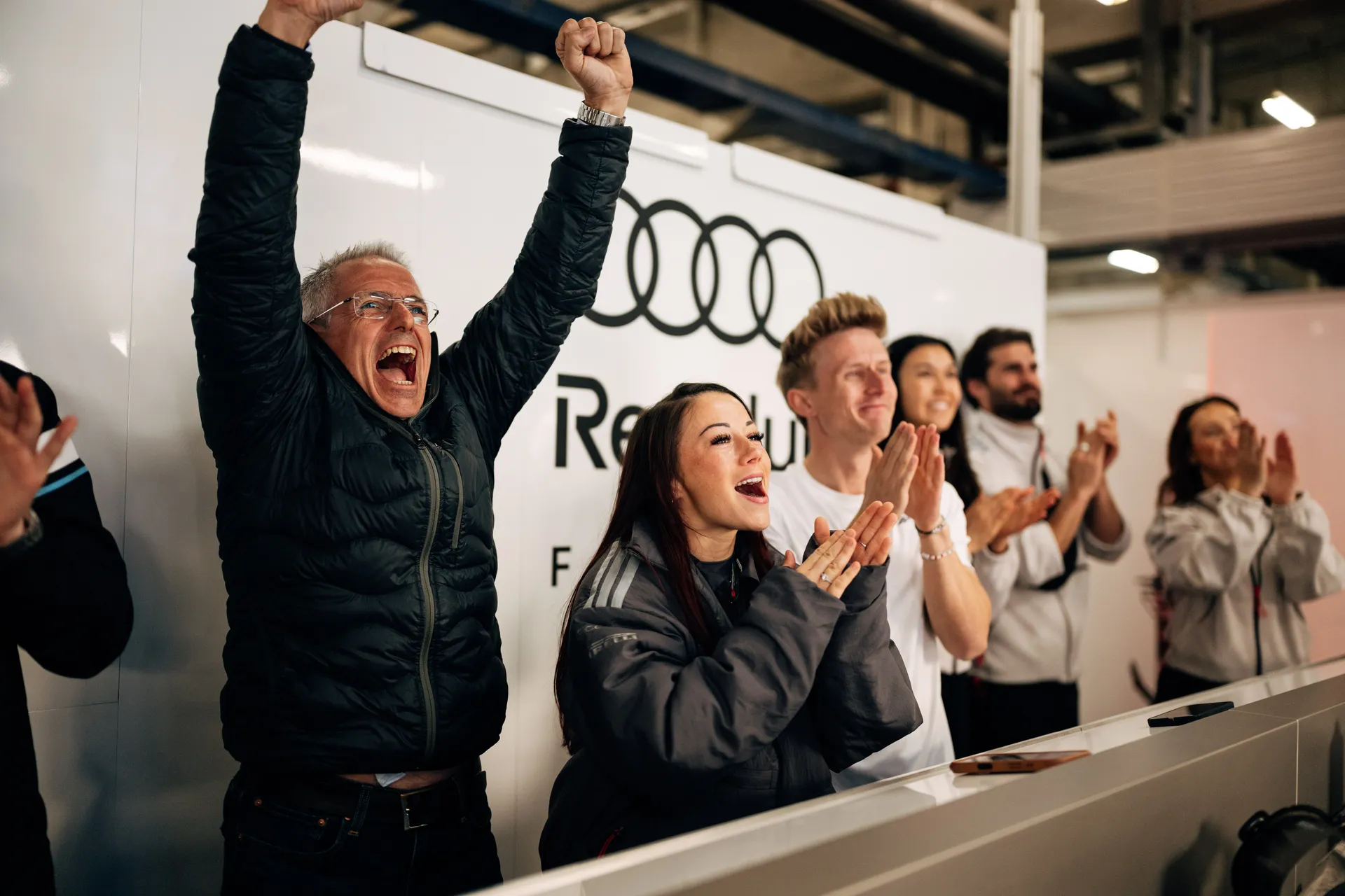 Audi Revolut F1® Team members celebrate in the garage with Carrie Schreiner while watching Emma Felbermayr’s F1 Academy race in Shanghai.