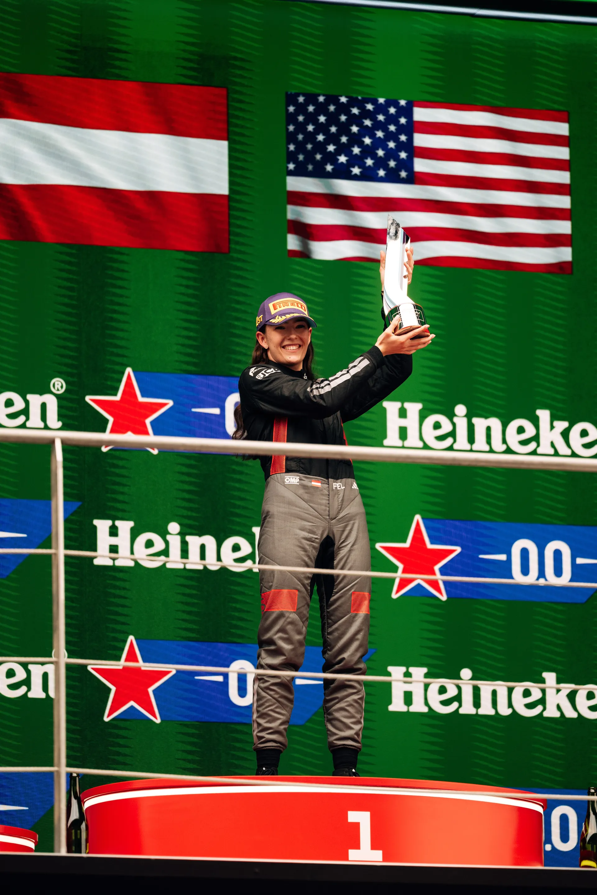 Emma Felbermayr stands on the top step of the podium holding her trophy after winning F1 Academy Race 2 in Shanghai.