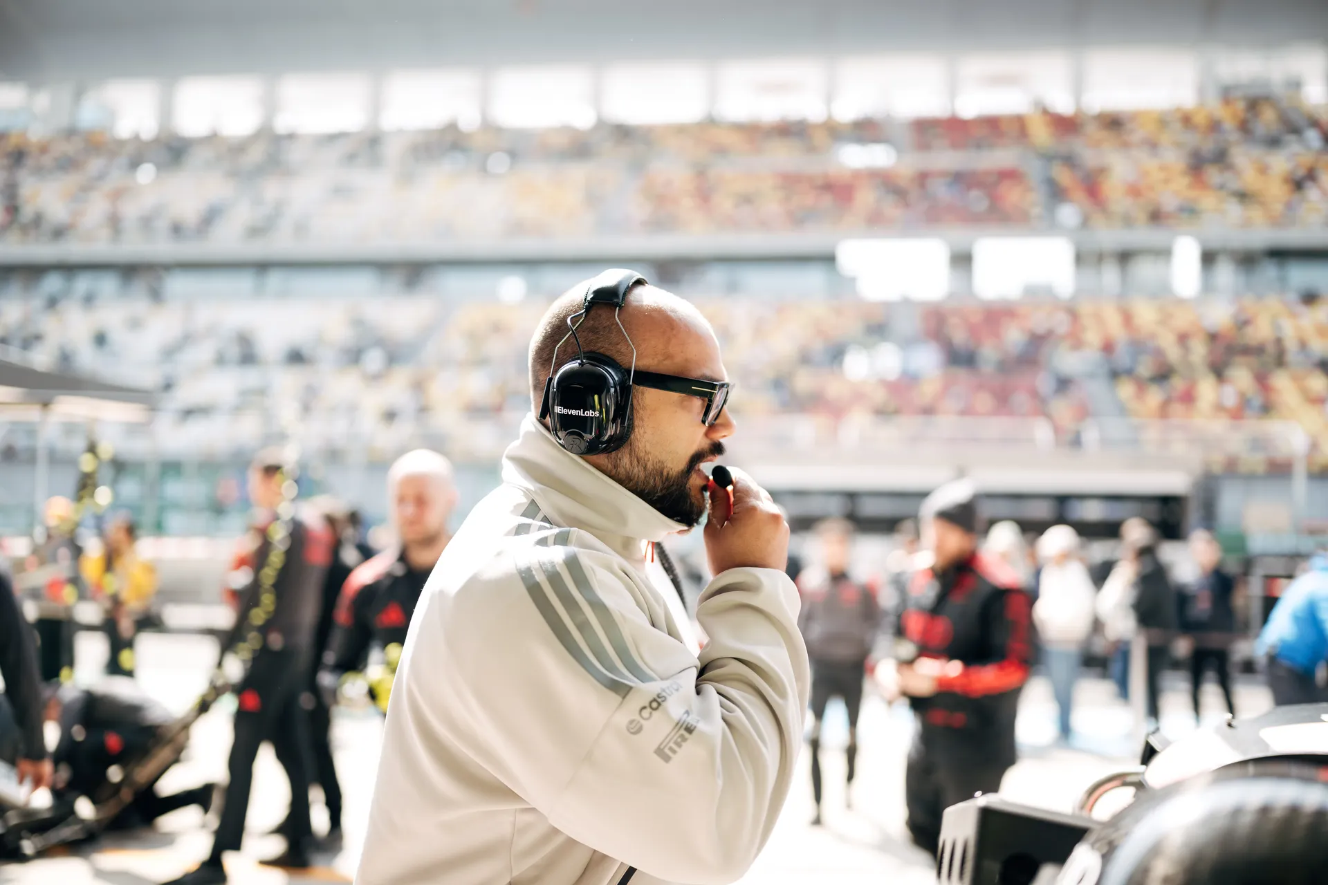 Audi Revolut F1® Team engineer wearing a headset and speaking into the radio on the Shanghai pit wall during track action.