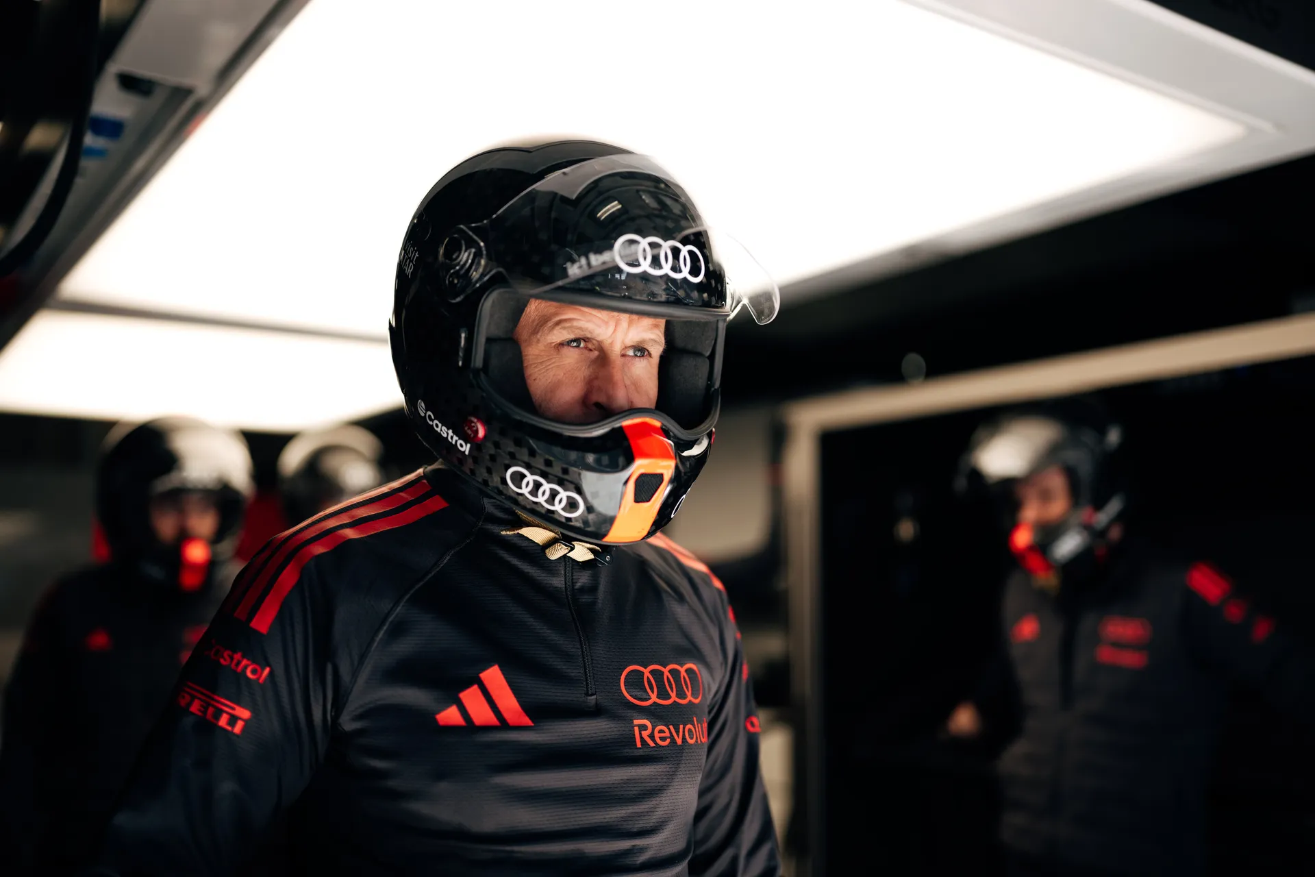 Audi Revolut F1® Team pit crew member in a helmet stands ready inside the Shanghai garage during practice preparations.