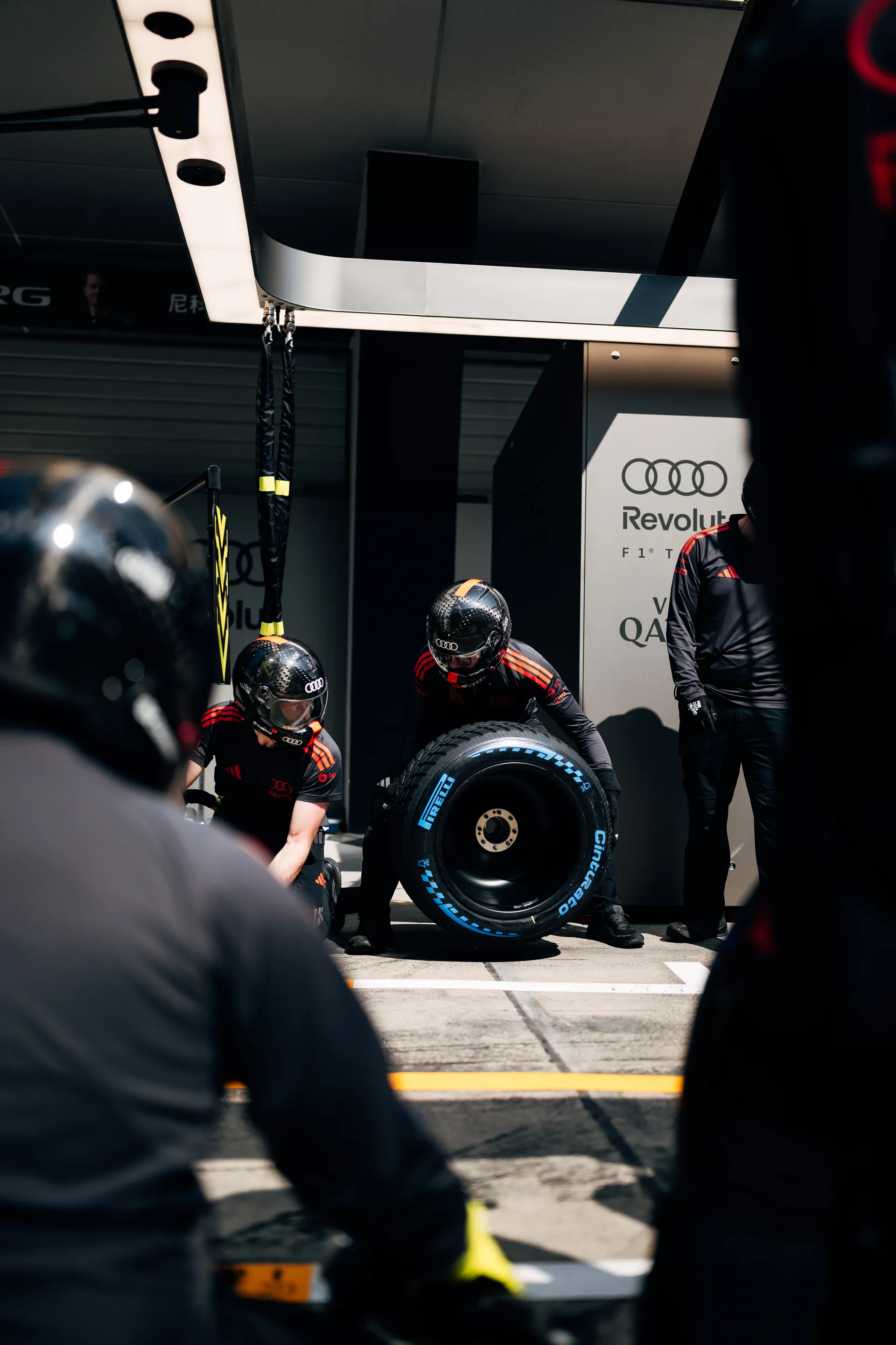 Audi Revolut F1® Team pit crew prepare a tyre in the pit lane during a practice stop in Shanghai.