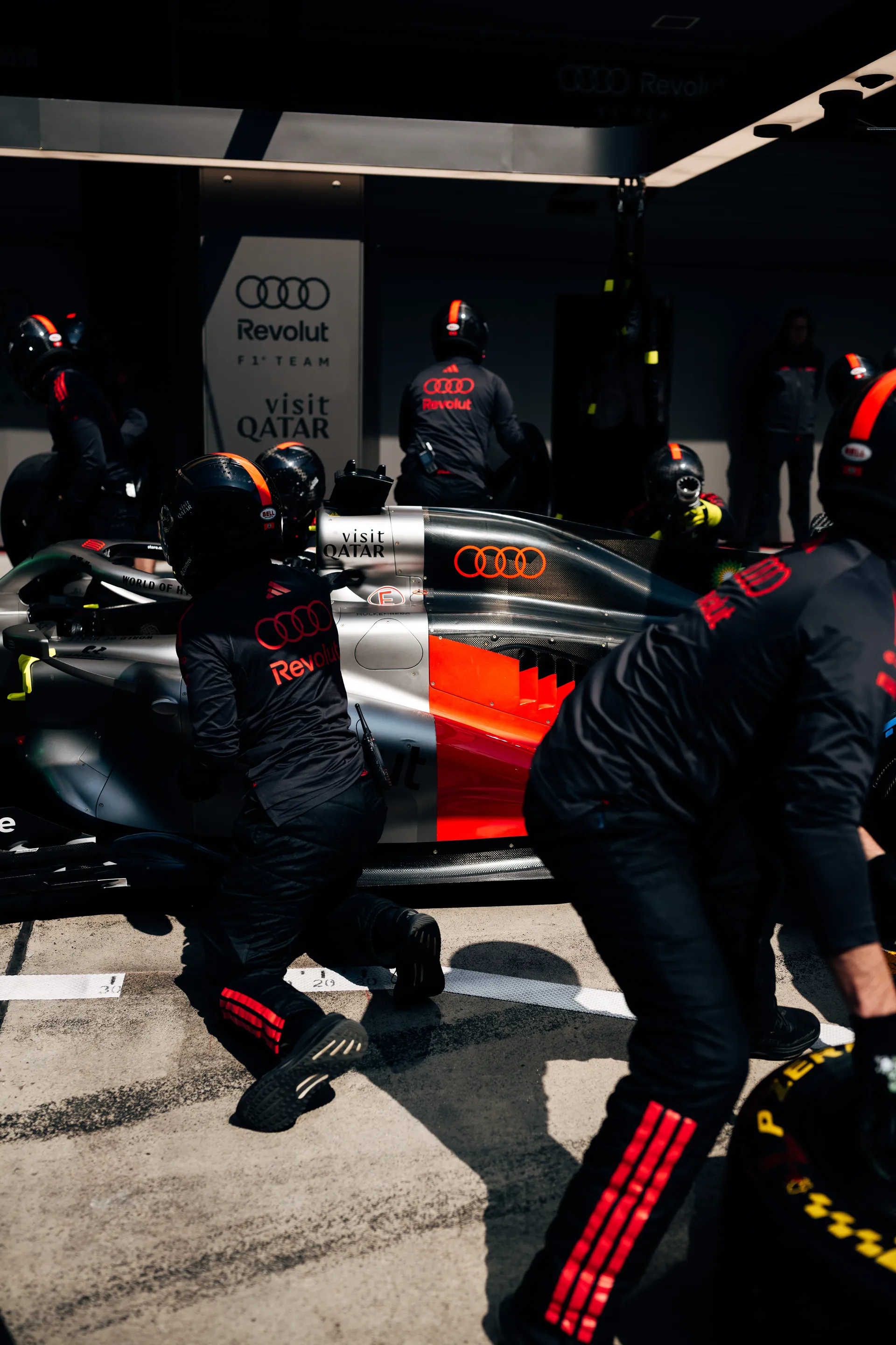 Audi Revolut F1® Team pit crew member works beside the race car in the Shanghai pit lane during practice.