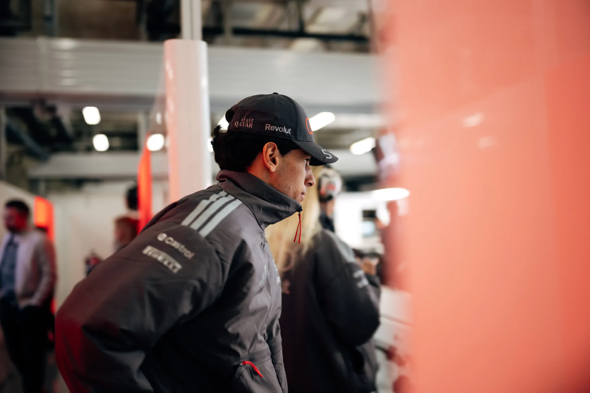 Side profile of Gabriel Bortoleto inside the Shanghai garage, wearing Audi Revolut F1® Team gear during race weekend preparations.