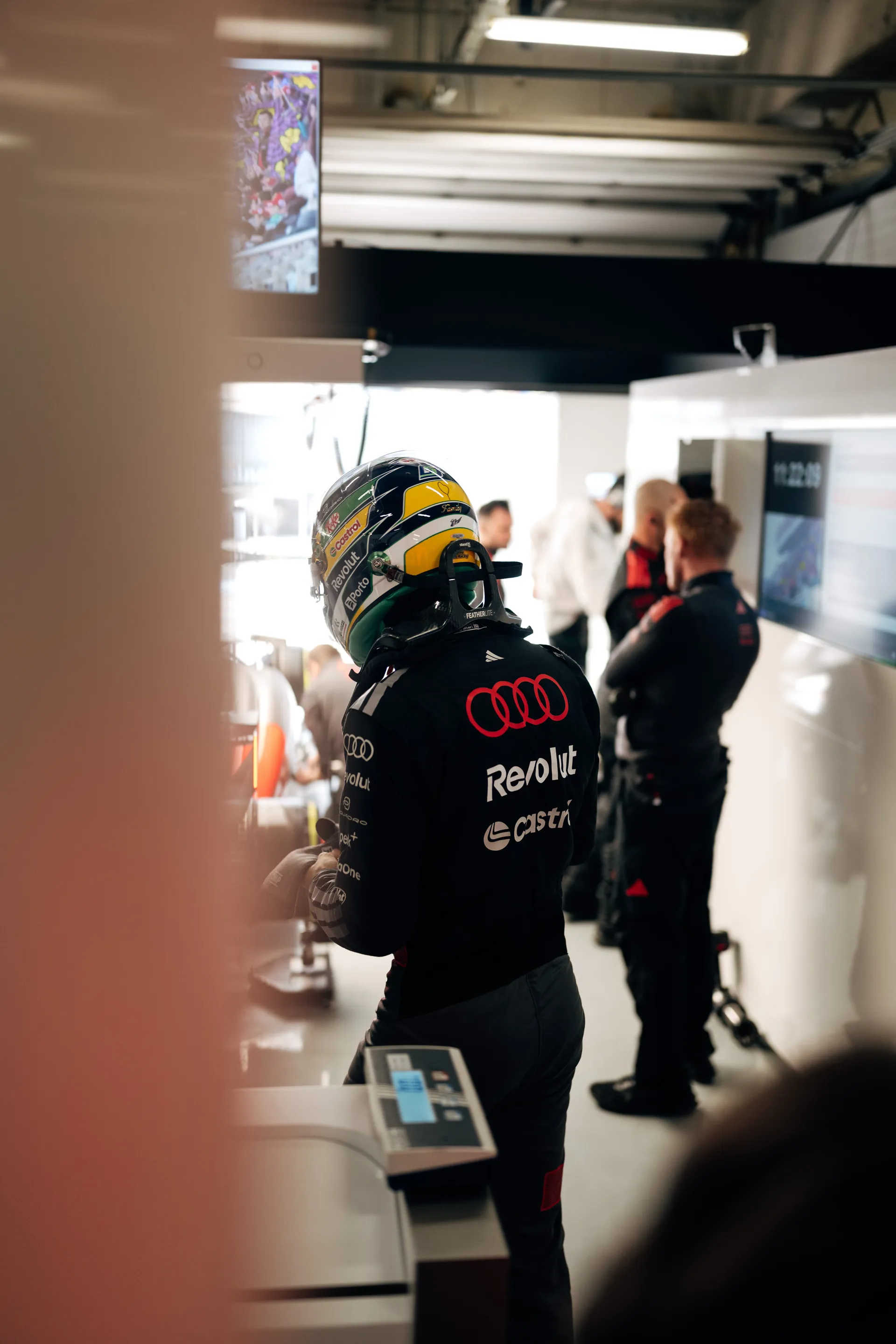 Gabriel Bortoleto stands in his pit bay wearing his helmet inside the Audi Revolut F1® Team garage in Shanghai.