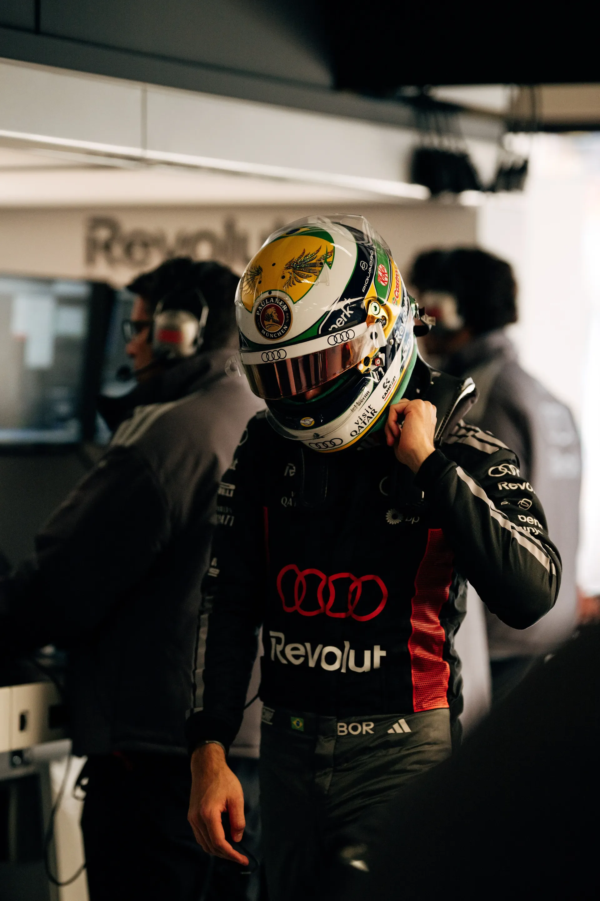 Gabriel Bortoleto stands in the Audi Revolut F1® Team garage wearing his helmet during the Chinese Grand Prix weekend.