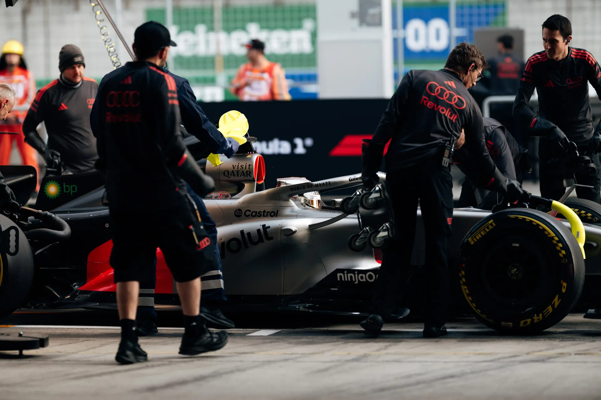 Pit crew of the Audi Revolut F1® Team working on the Formula 1 car during a pit stop practice.