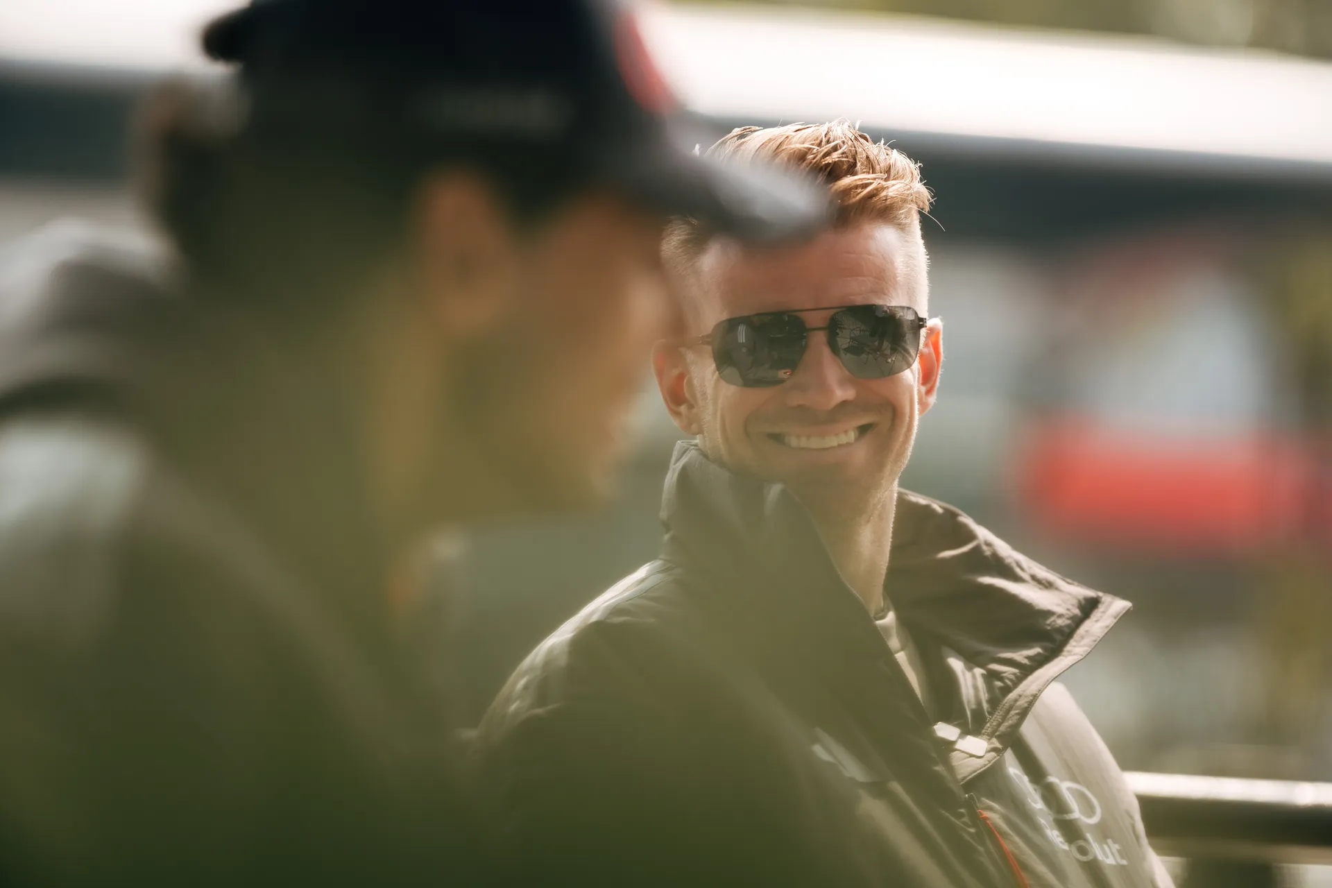 An Audi Revolut F1® Team driver Nico Hulkenberg smiles in conversation in the Shanghai paddock during race weekend.