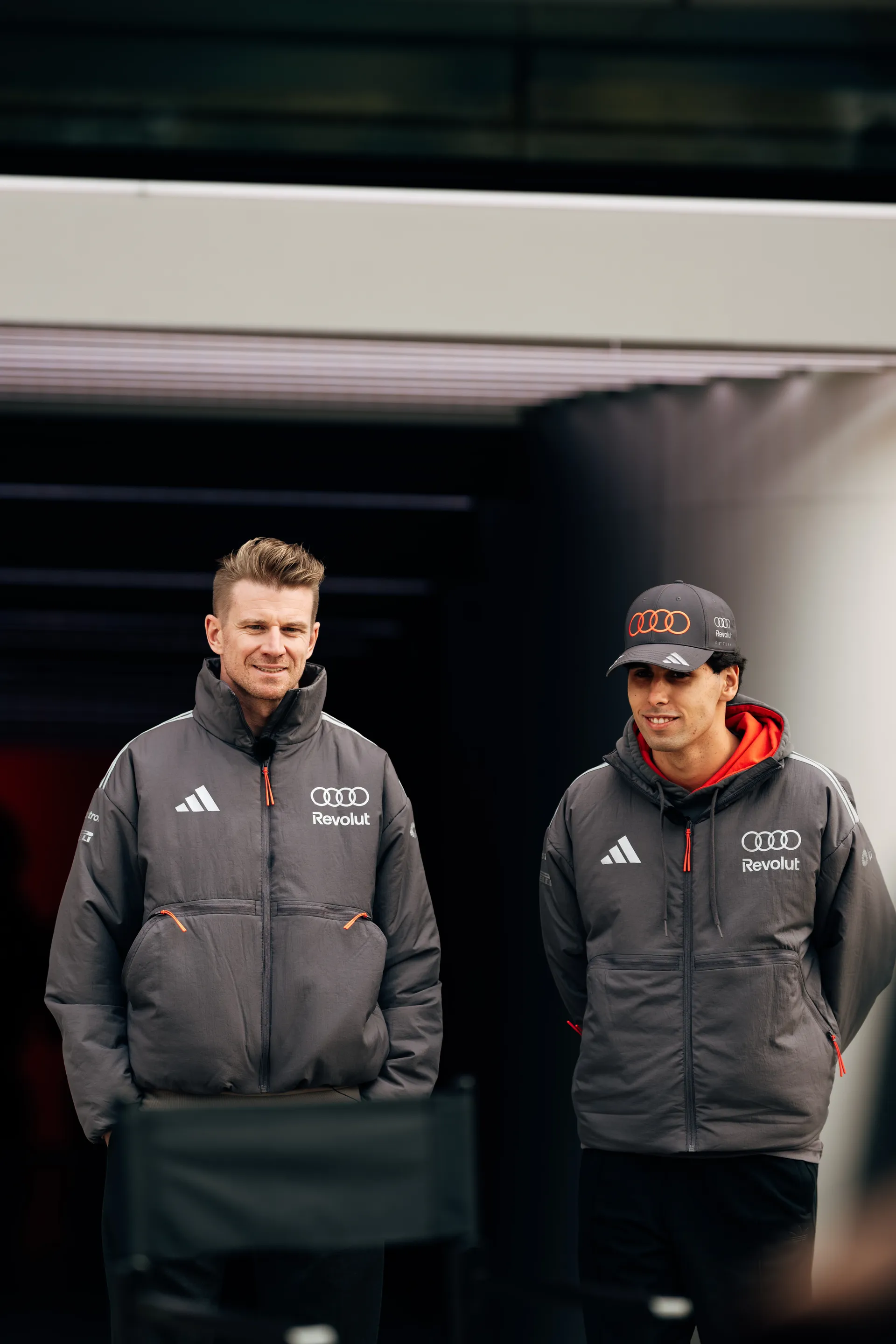 Nico Hulkenberg and Gabriel Bortoleto stand together outside the Audi Revolut F1® Team garage during the Chinese Grand Prix weekend.