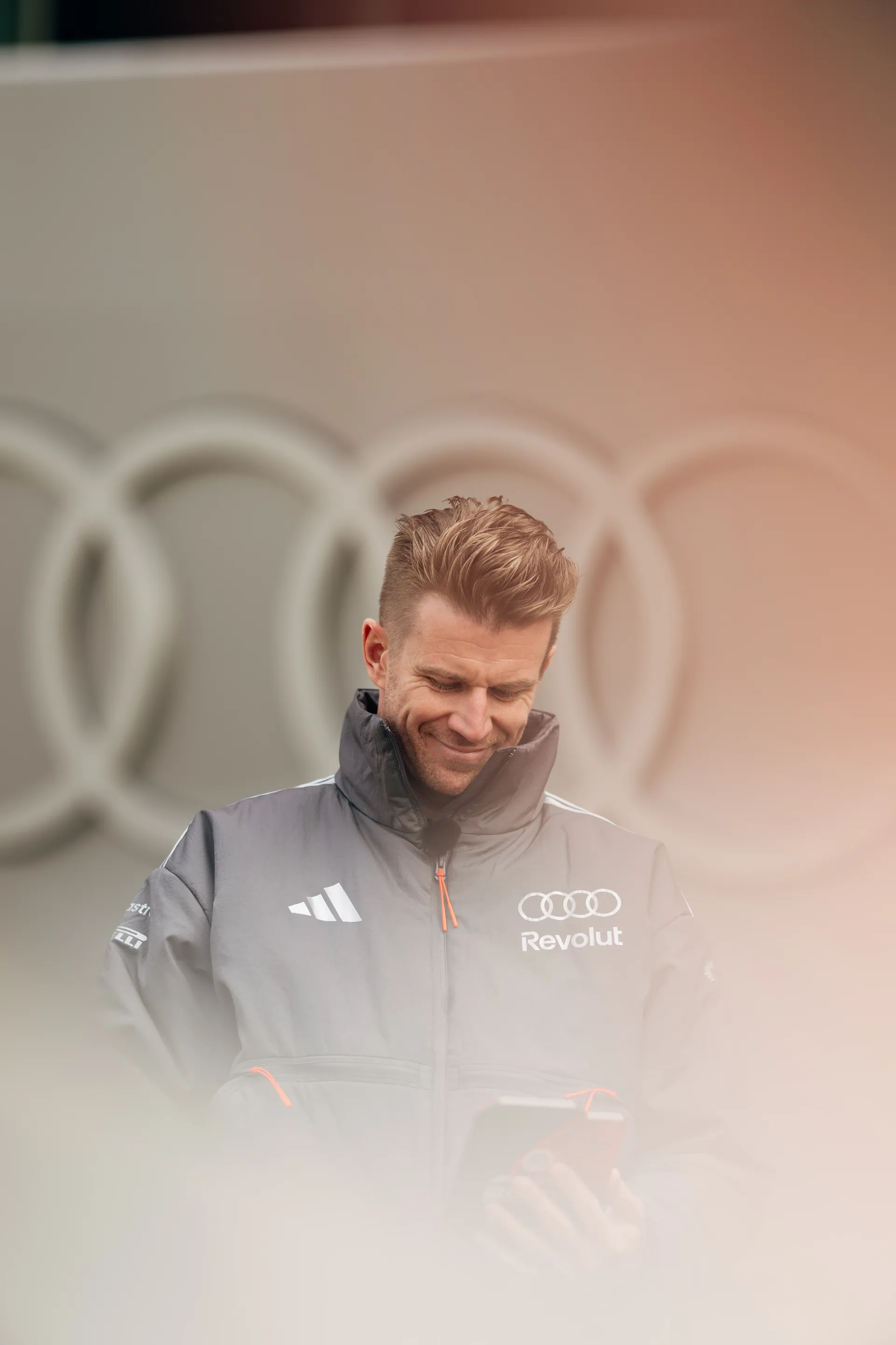 Nico Hulkenberg looks down at his phone outside the Audi Revolut F1® Team garage in Shanghai.