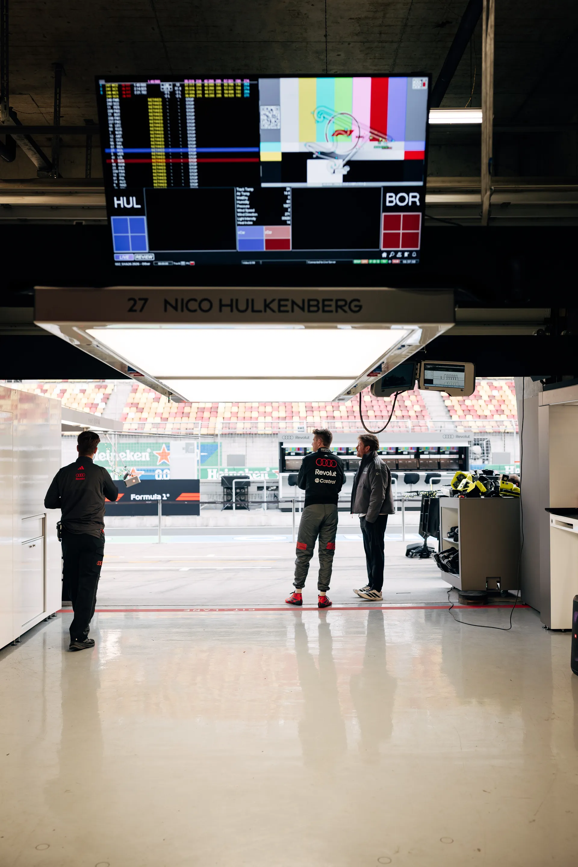 View from inside the Audi Revolut F1® Team garage in Shanghai, with Nico Hulkenberg’s pit bay signage and timing screens above the pit lane.