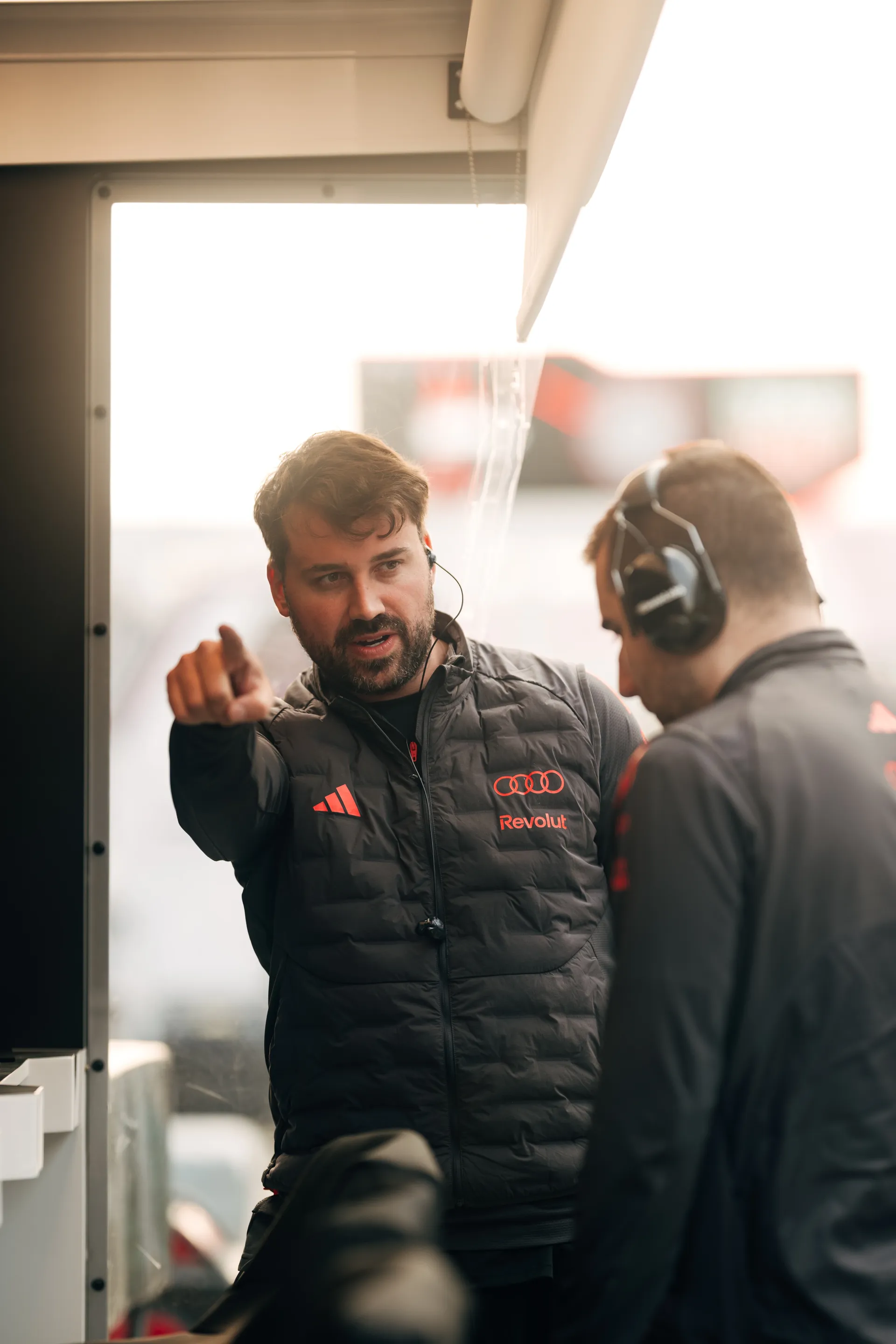 Two Audi Revolut F1® Team crew members discuss setup details inside the Shanghai garage during race weekend preparations.