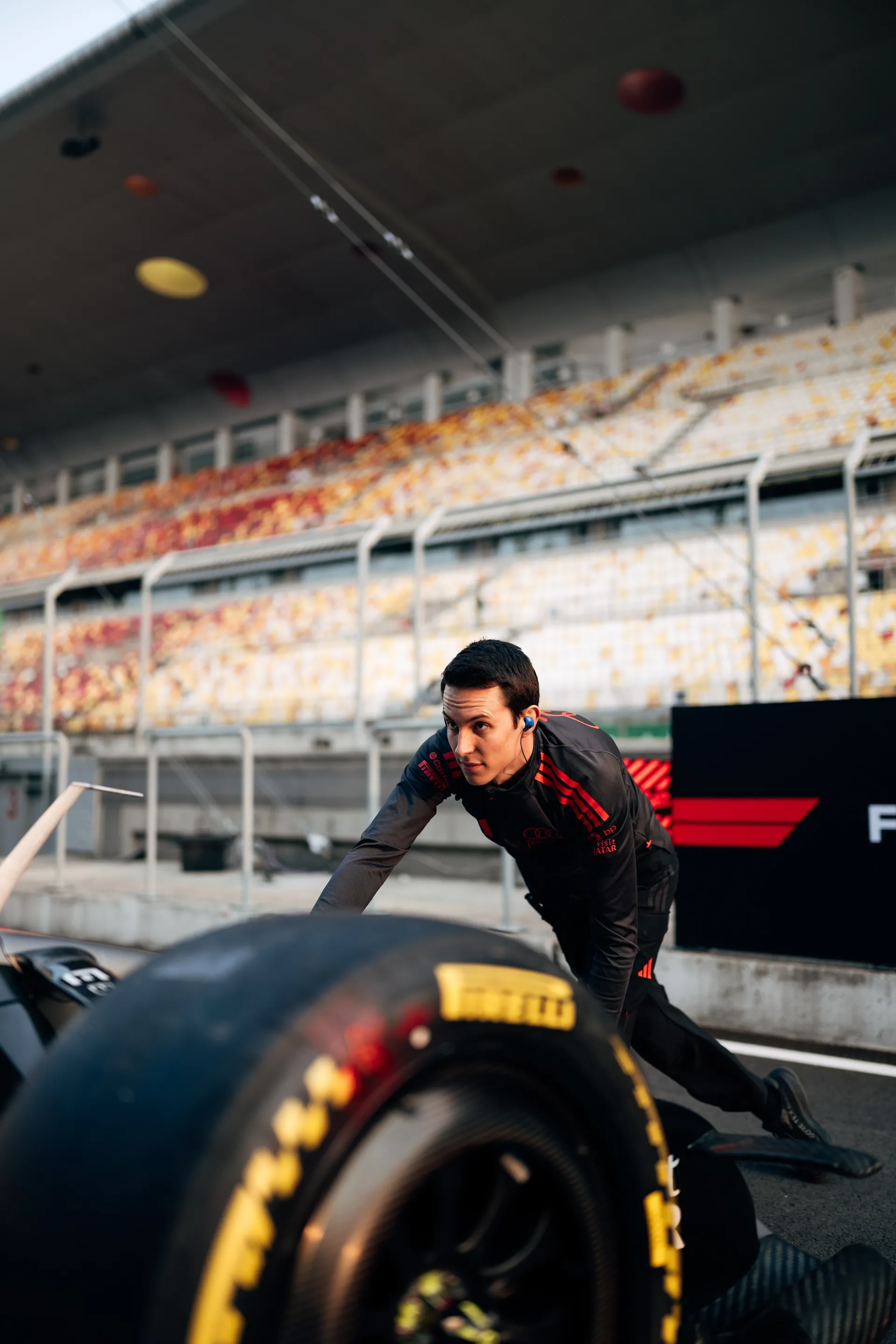 Audi Revolut F1® Team crew member pushes a race car component in the Shanghai pit lane during preparation work.