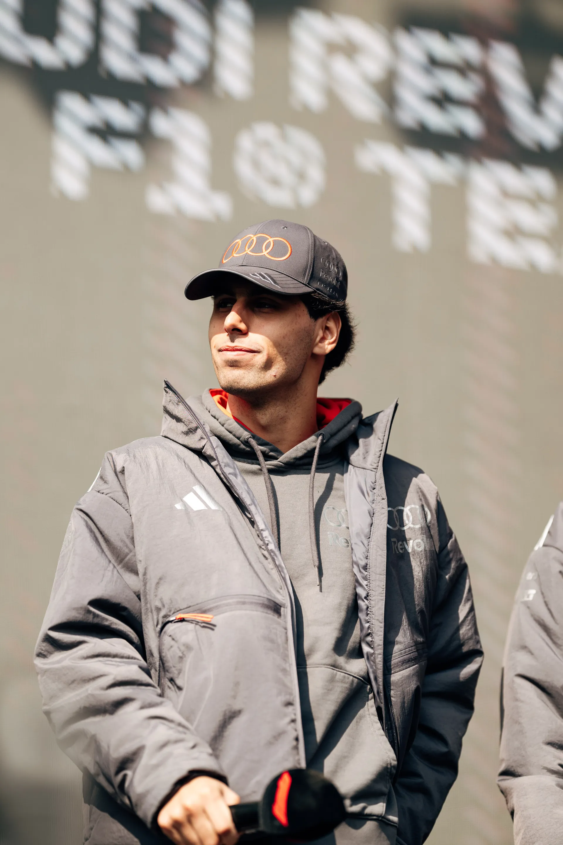Gabriel Bortoleto stands on stage in Audi Revolut F1® Team gear during a public appearance in Shanghai.
