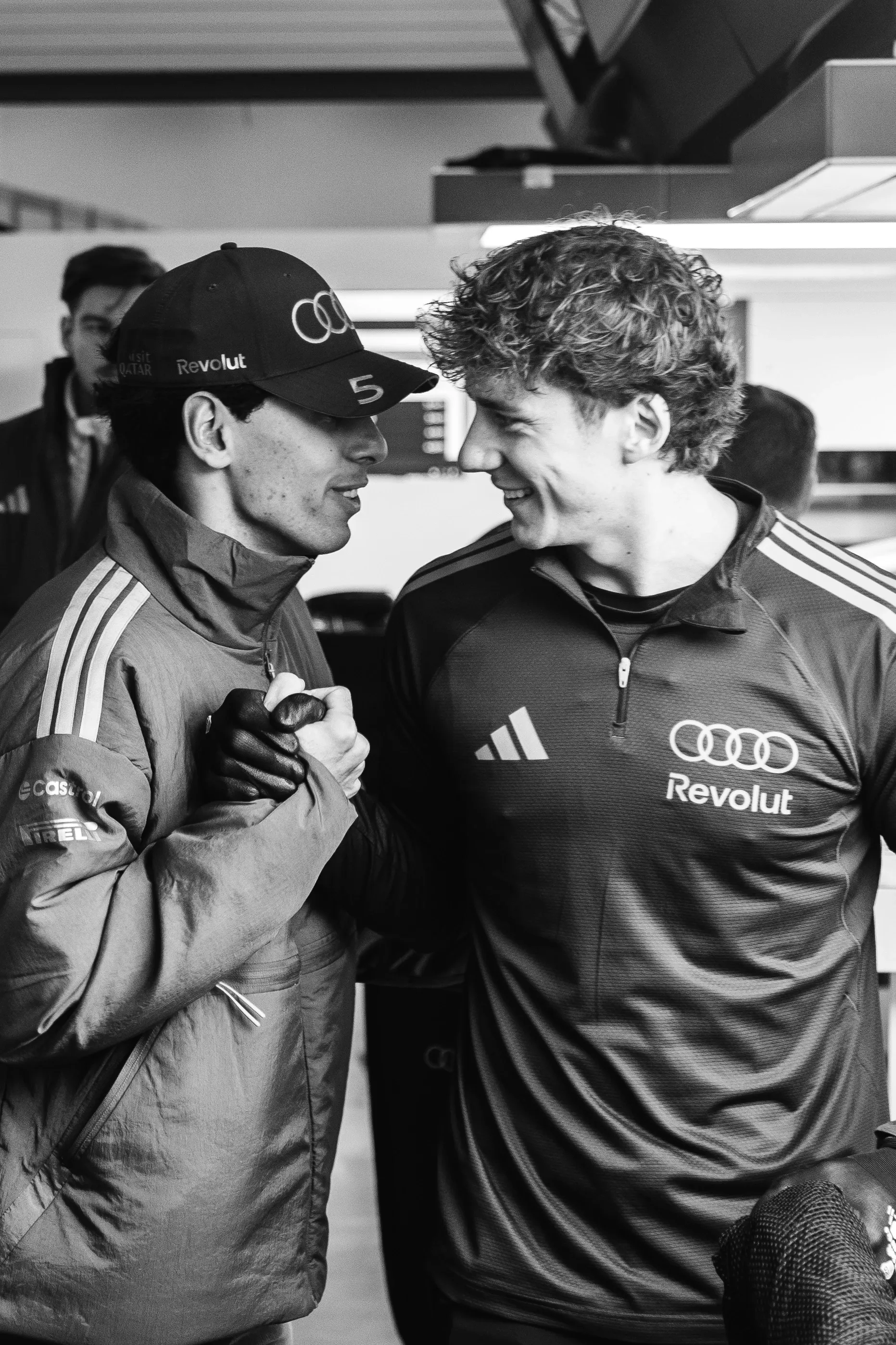 Gabriel Bortoleto greets another team member inside the garage during race day arrival at the Chinese Grand Prix.