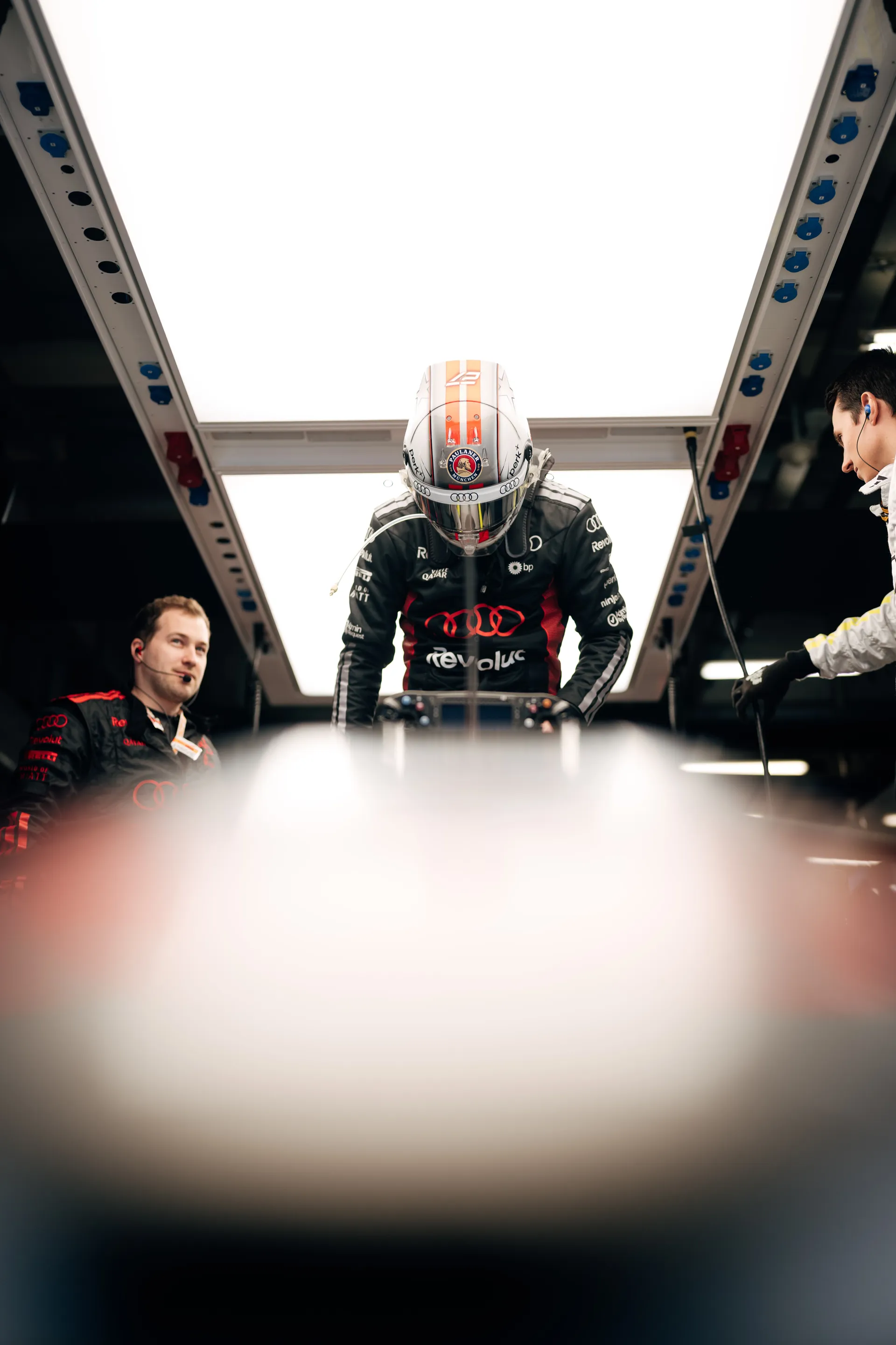 Nico Hulkenberg getting ready to race in the Audi Revolut F1® Team garage in full race suit and helmet before heading out on track.