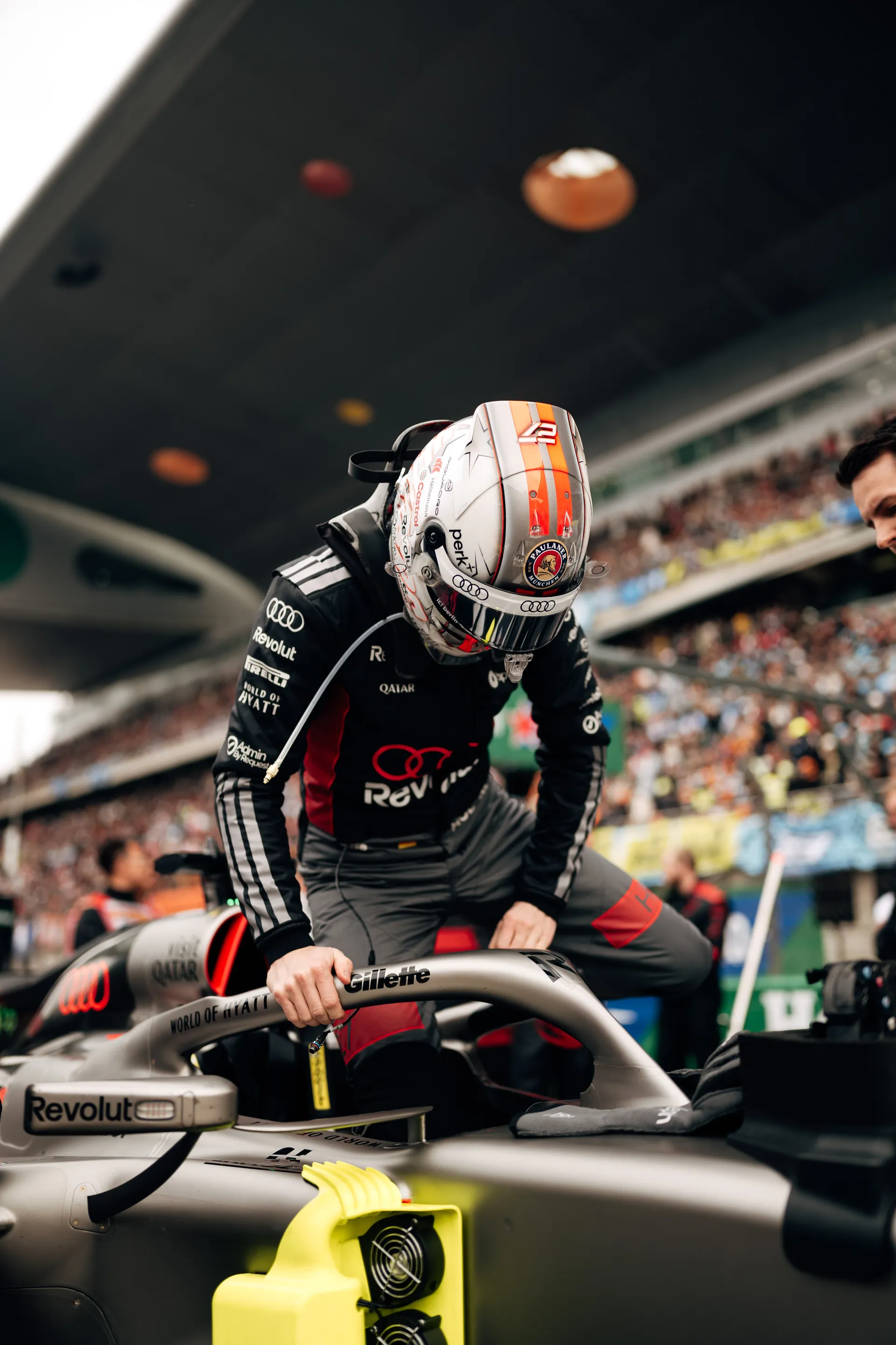 Nico Hulkenberg climbs into the Audi Revolut F1® Team car on the grid before the race at the Chinese Grand Prix.