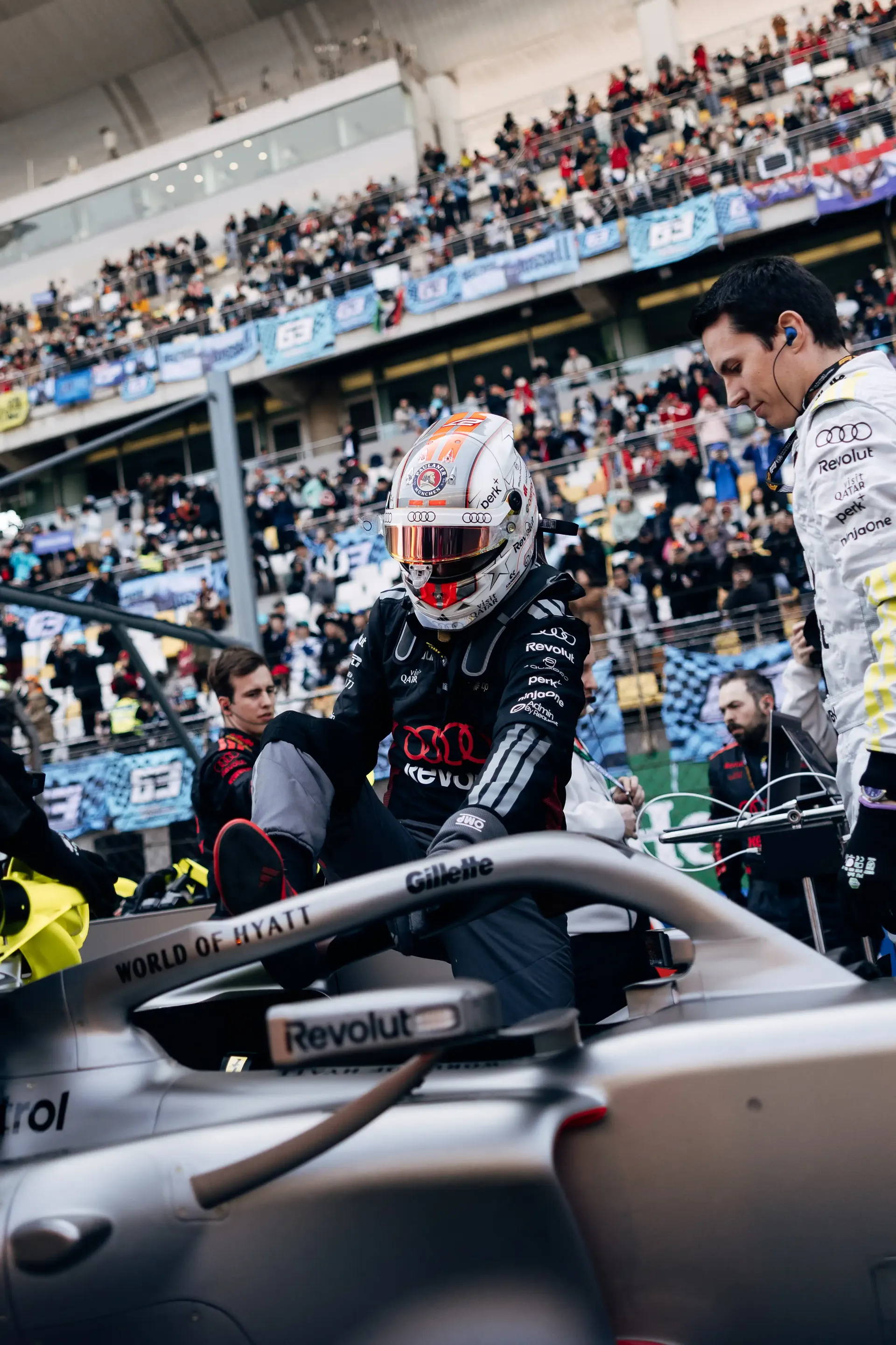 Audi Revolut F1® Team driver Nico Hulkenberg leaning over the Formula 1 car during pre-race preparation.