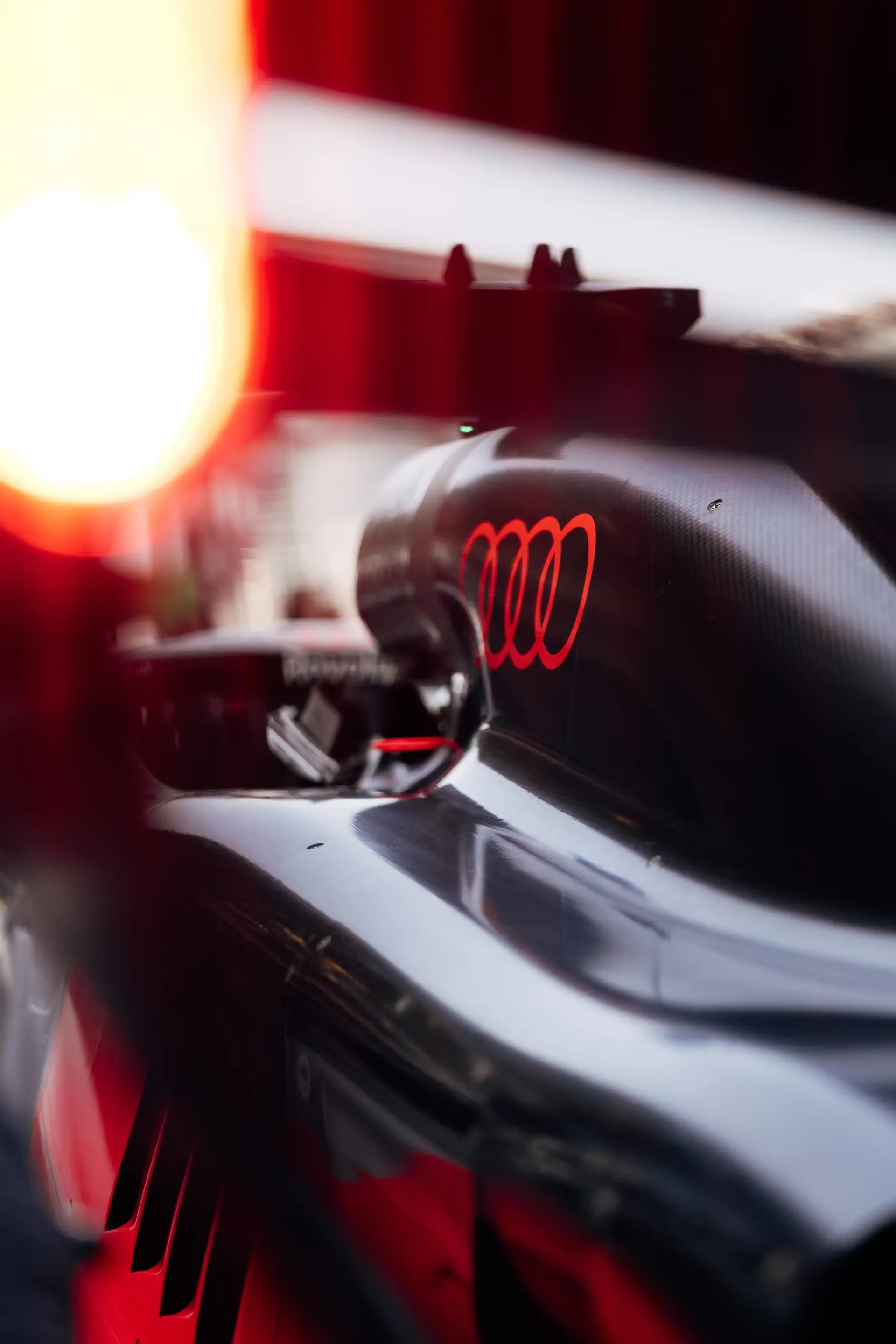 Audi Revolut F1® Team Formula 1 car photographed in the garage with dramatic lighting.